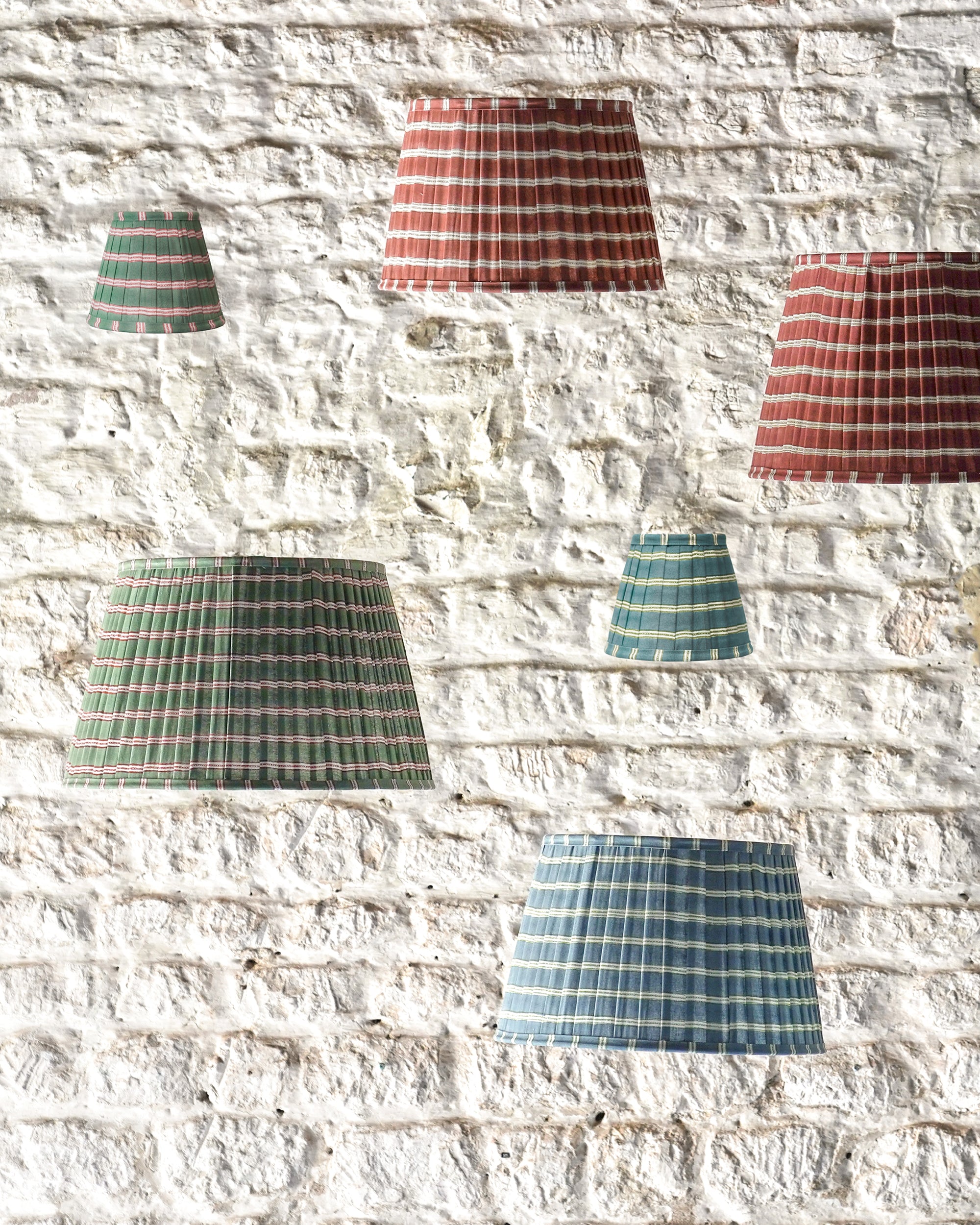 Set of checkered lampshades in various colors against a textured stone wall.