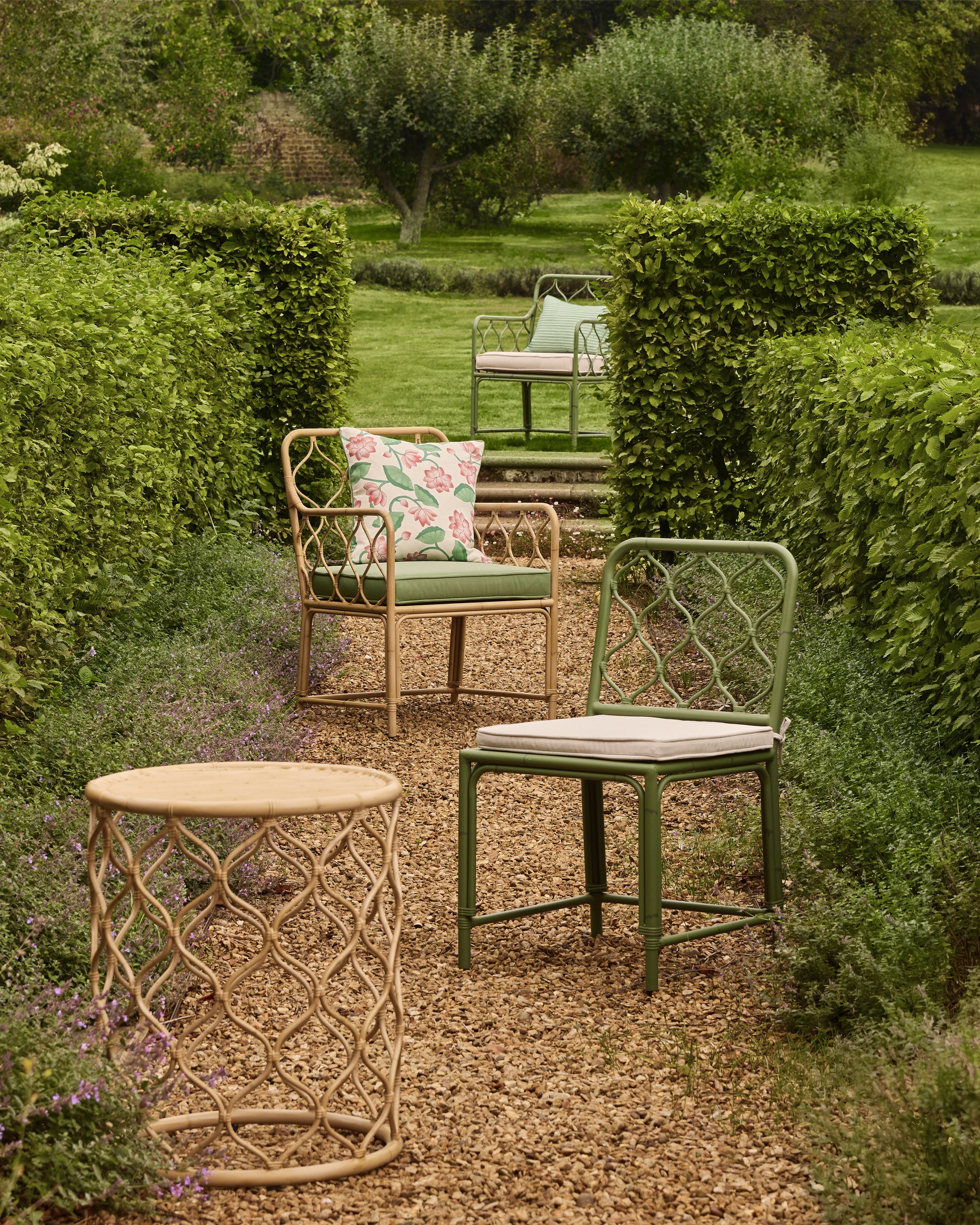 Outdoor garden setting with chairs and a table in a green landscape
