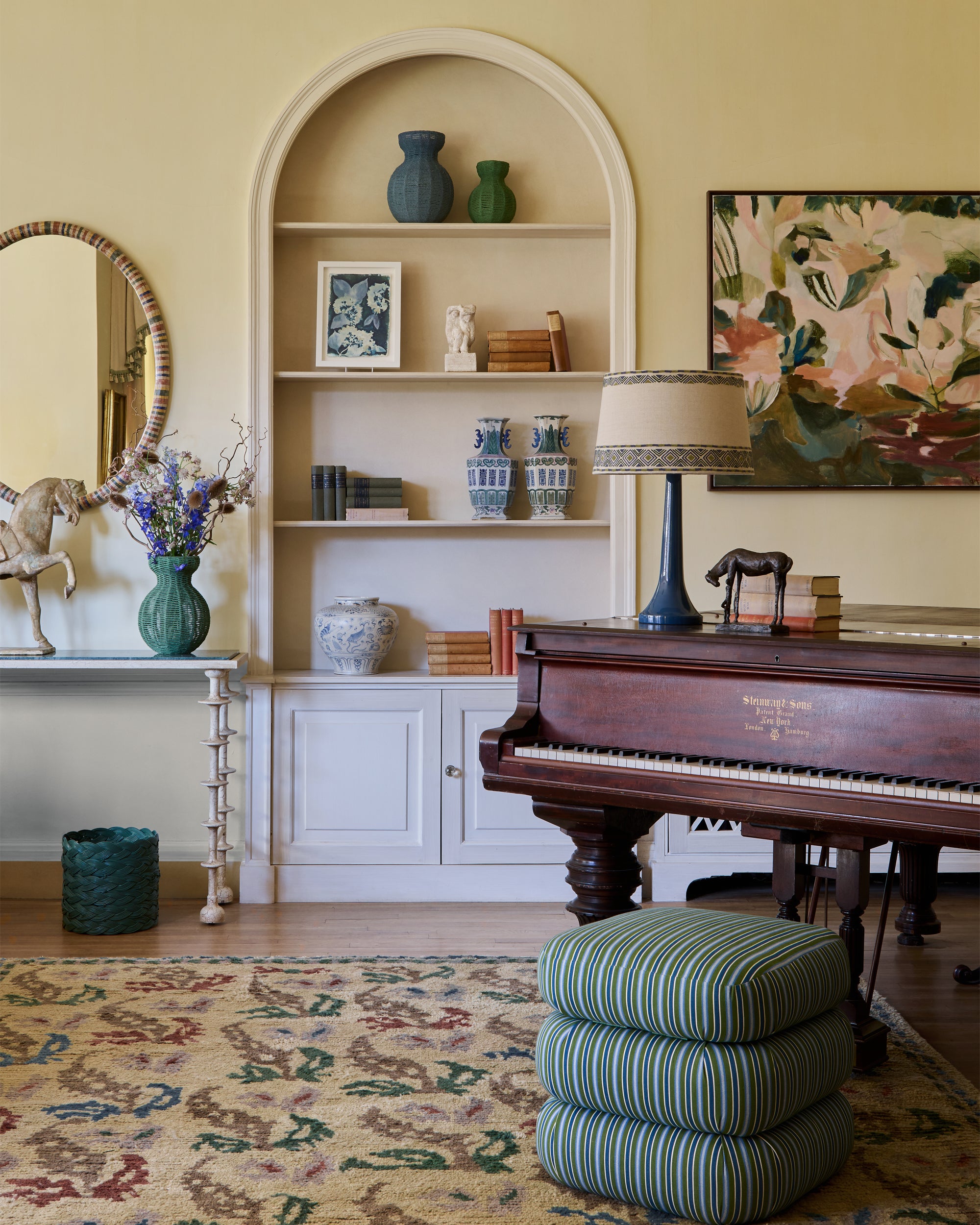 Living room with a piano, shelves, and decorative items.