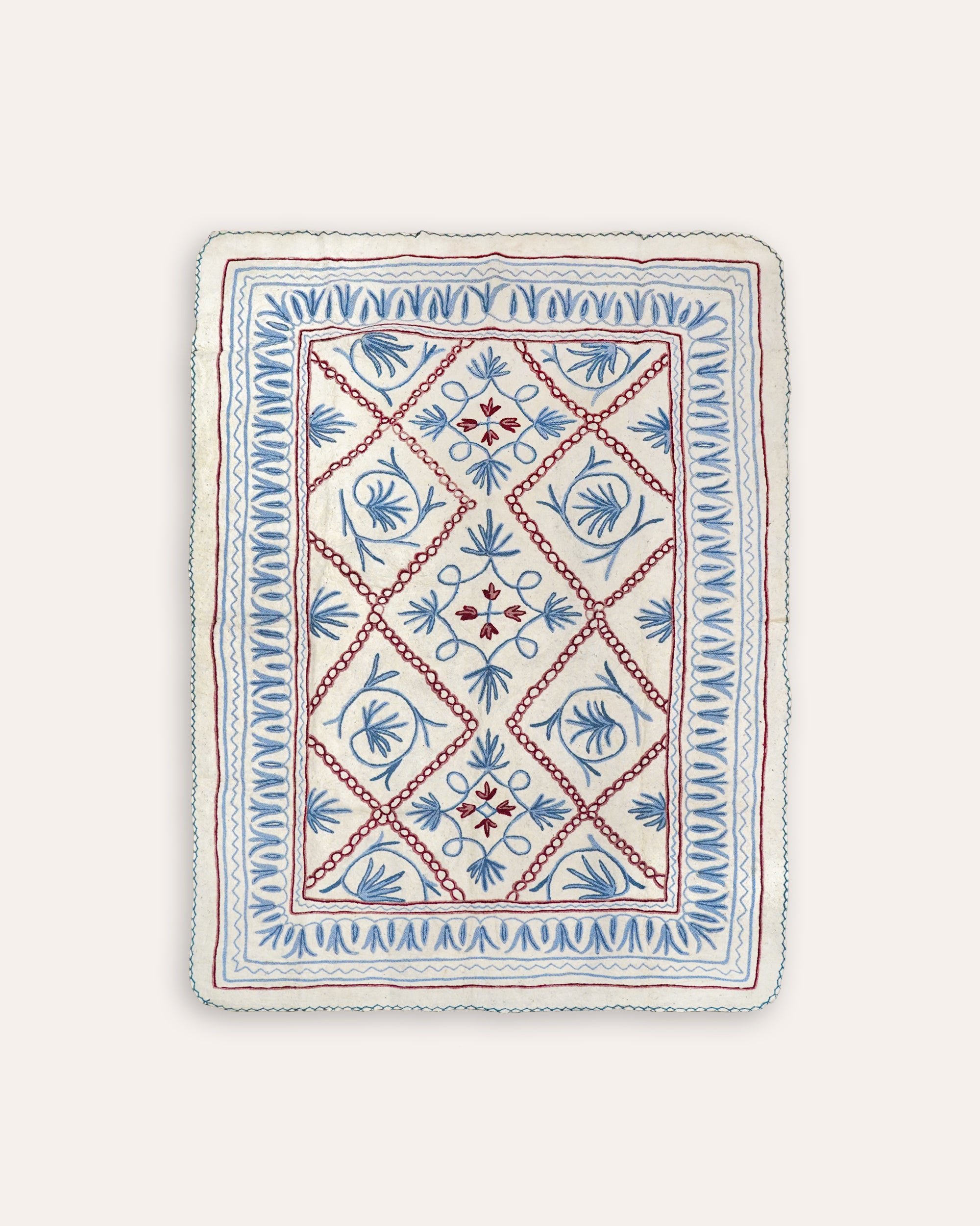 Decorative blue and red Namda rug product image on a taupe background