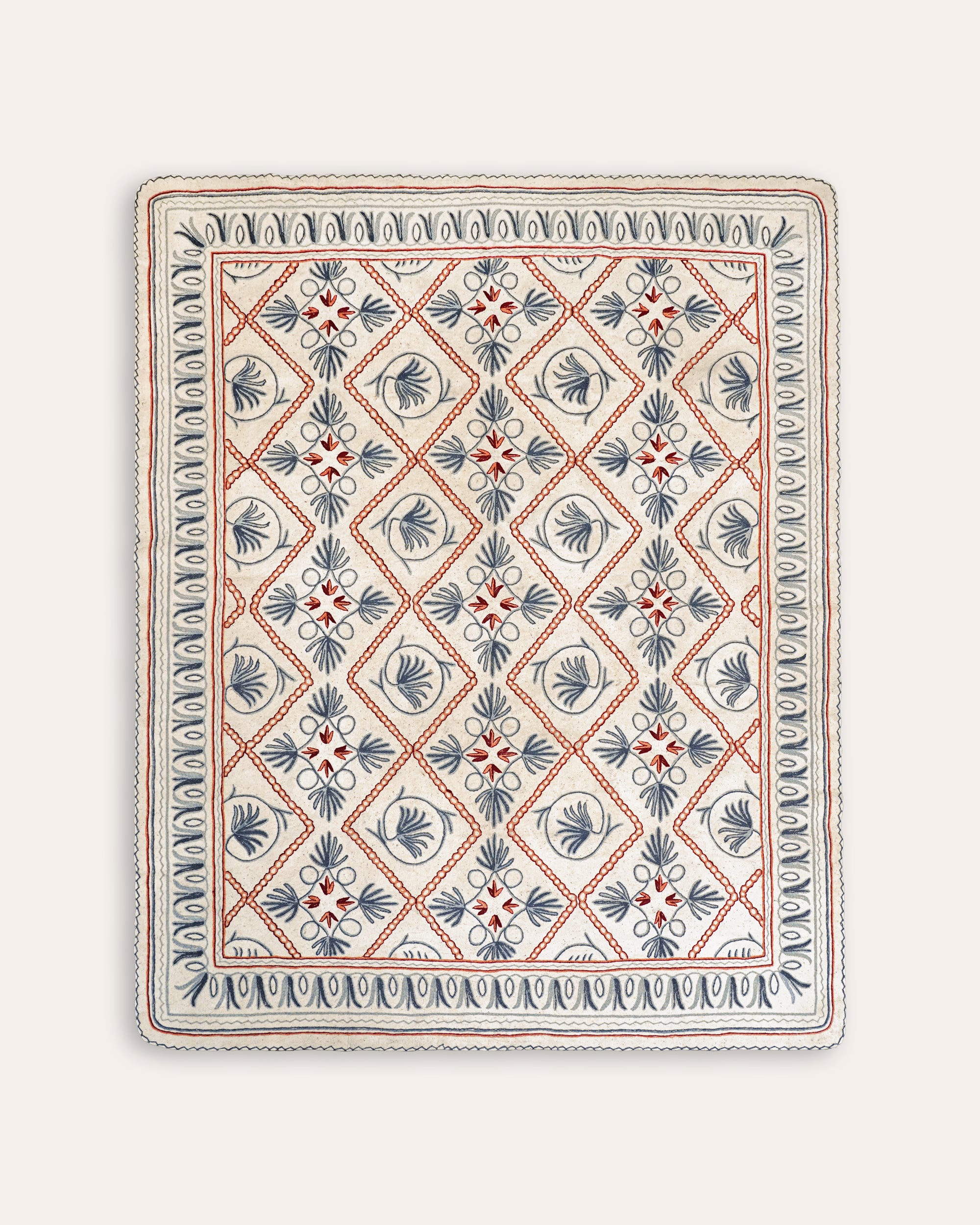 A rectangular felt rug with floral embroidery in blue, pink, and white colors.