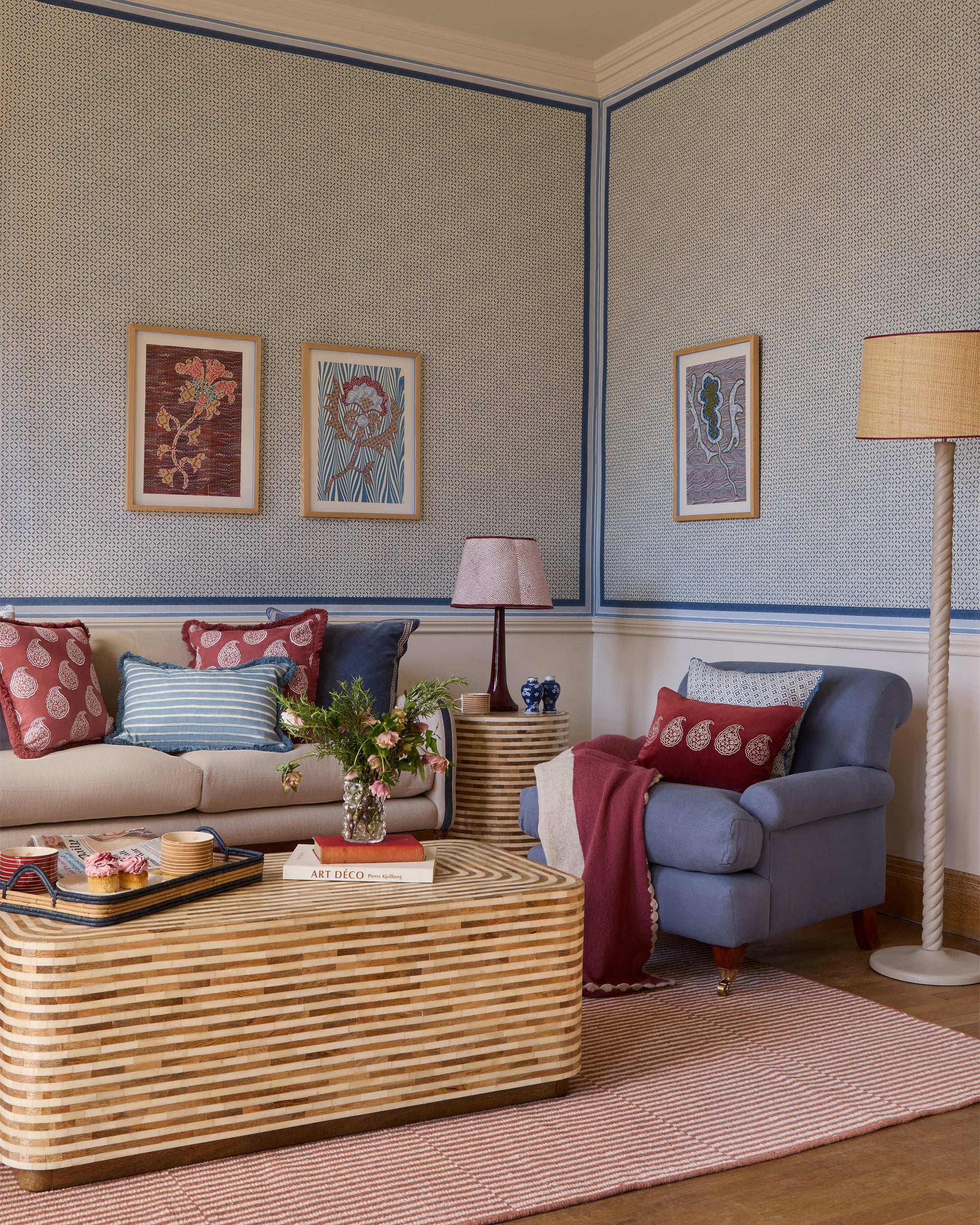 Living room with a beige sofa, blue armchair, and wicker coffee table.