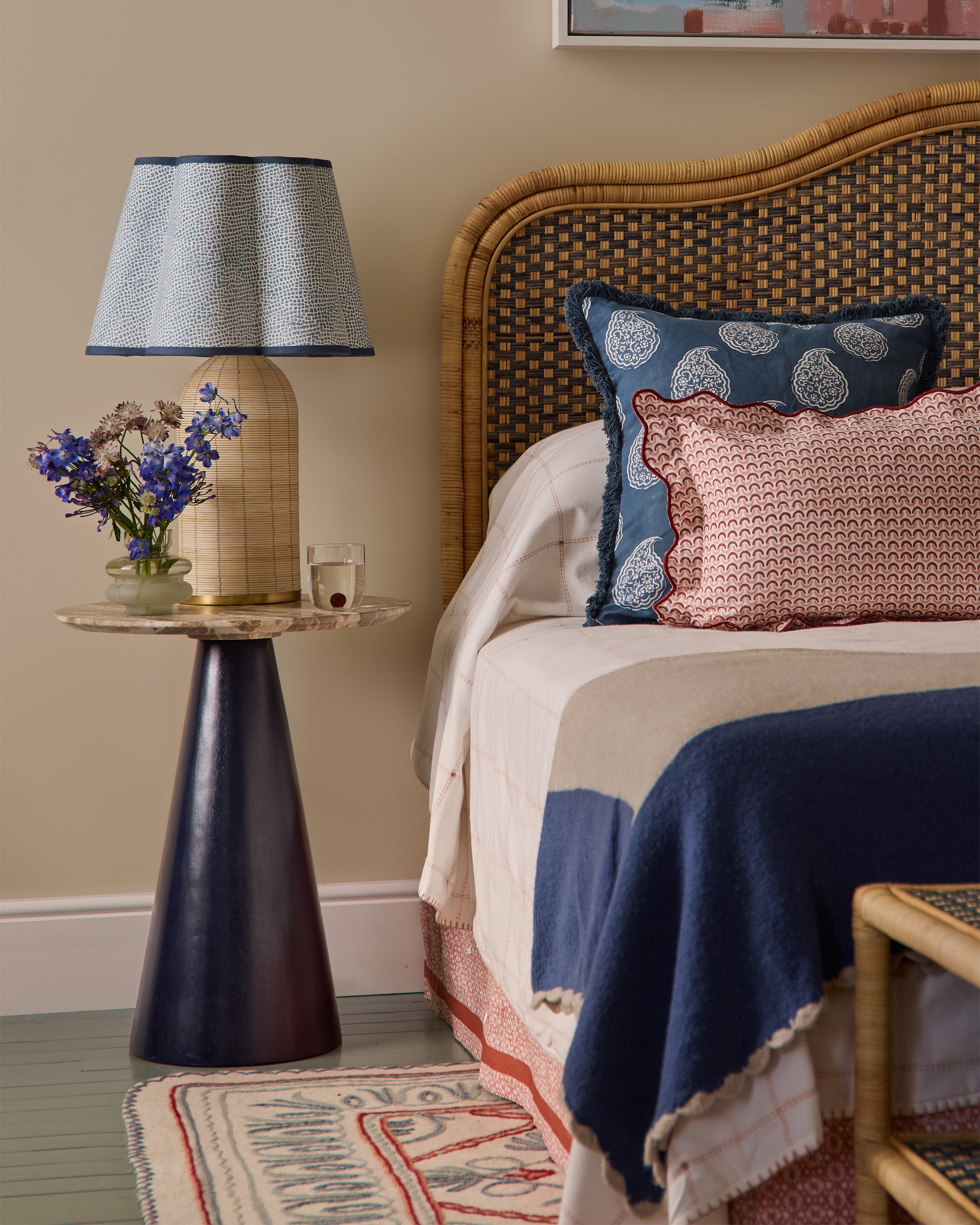 Bedroom with wicker headboard, patterned bedding, and decorative pillows.