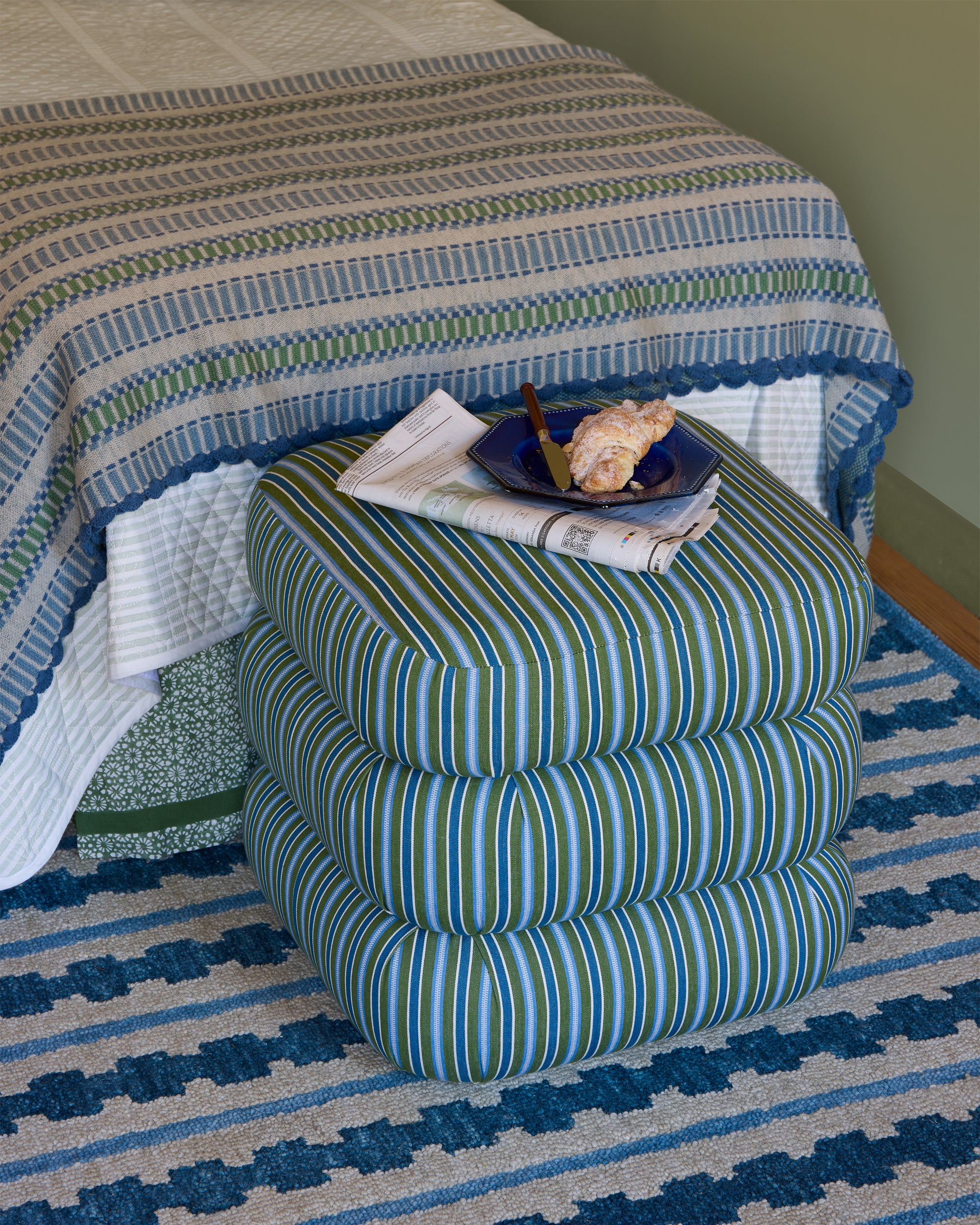 Striped stool with a plate of food on a patterned rug