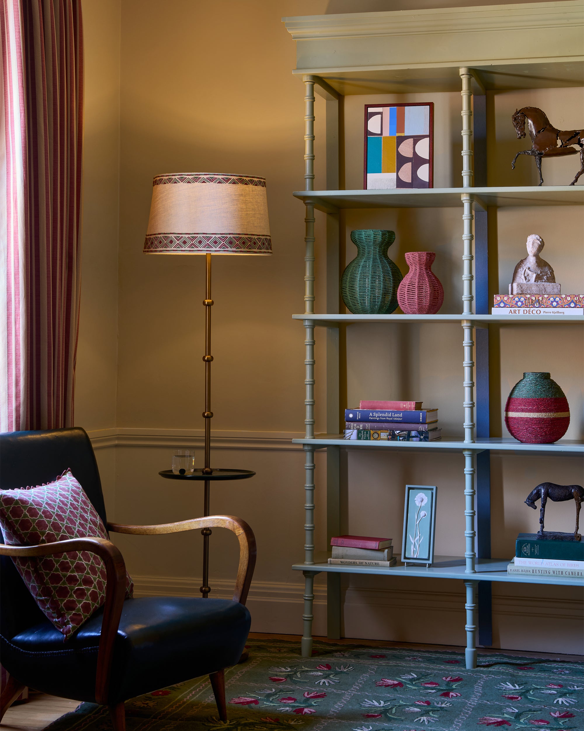 Living room with a bookshelf, armchair, and floor lamp.