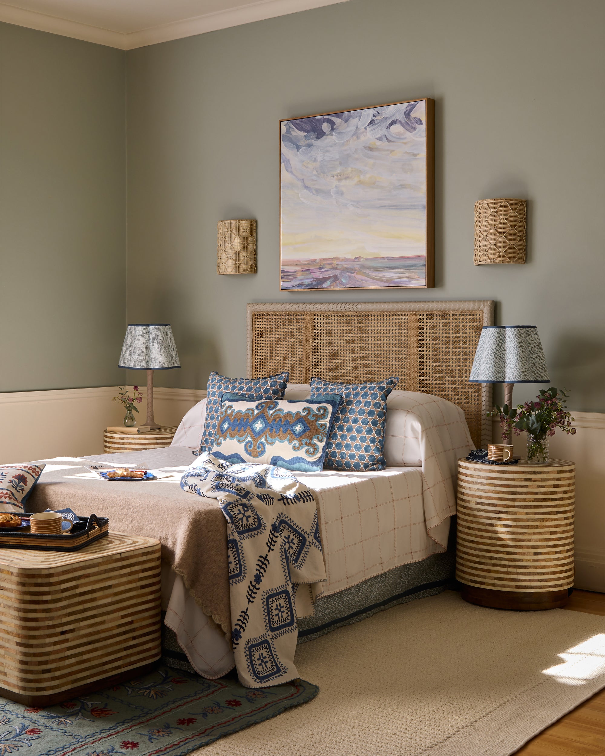 Cozy bedroom with a natural pavilion headboard and nightstands, featuring a painting on the wall.