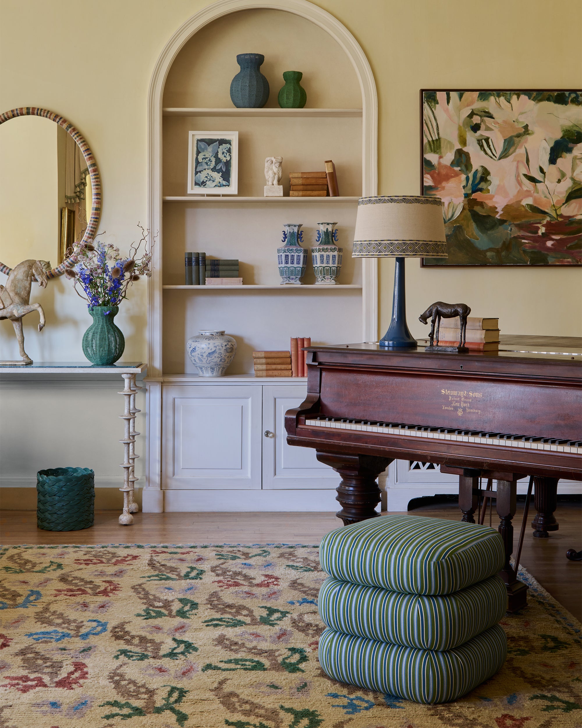 Living room with a piano, shelves, and decorative items.