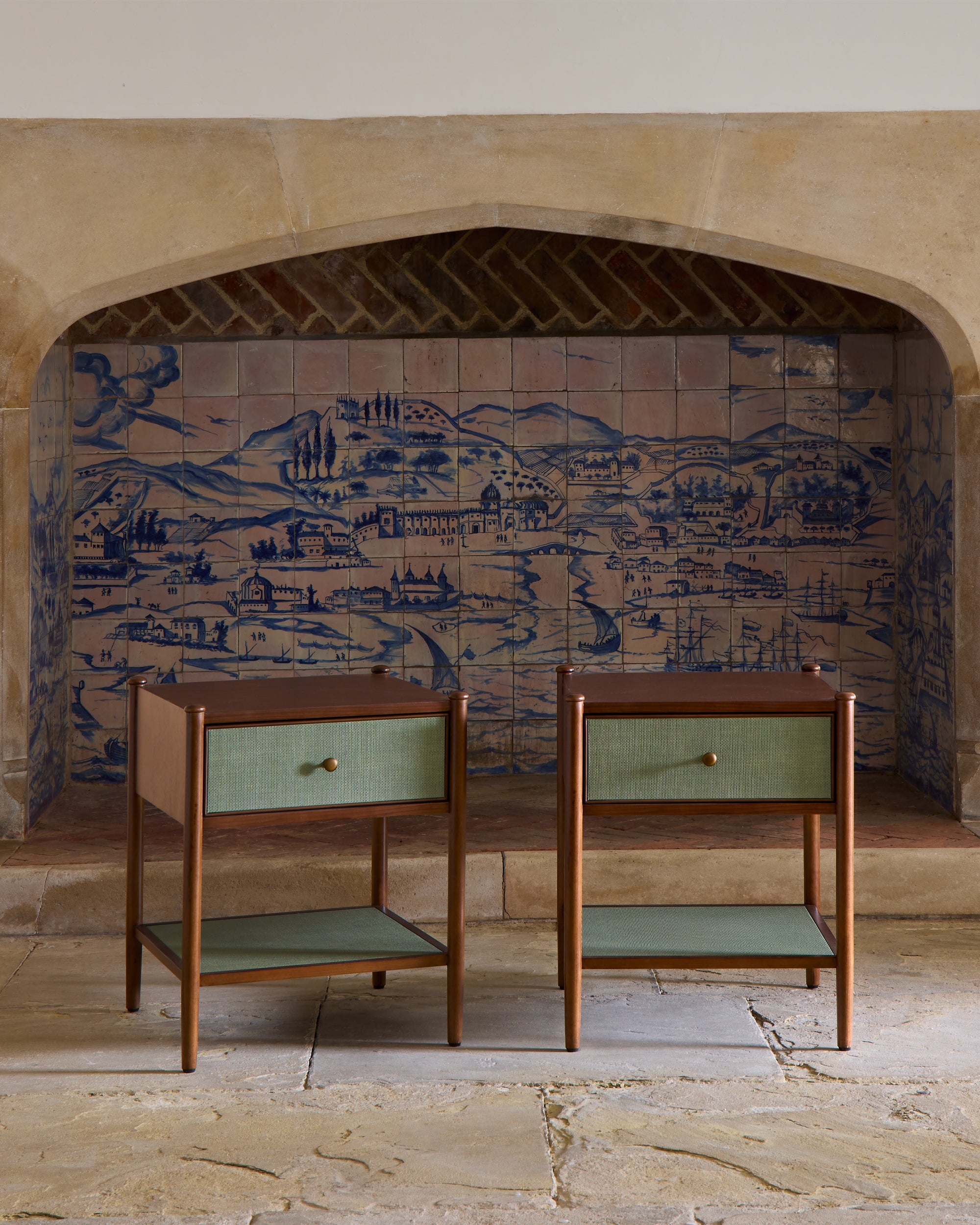 Two wooden side tables with green shelves against a decorative tiled wall.
