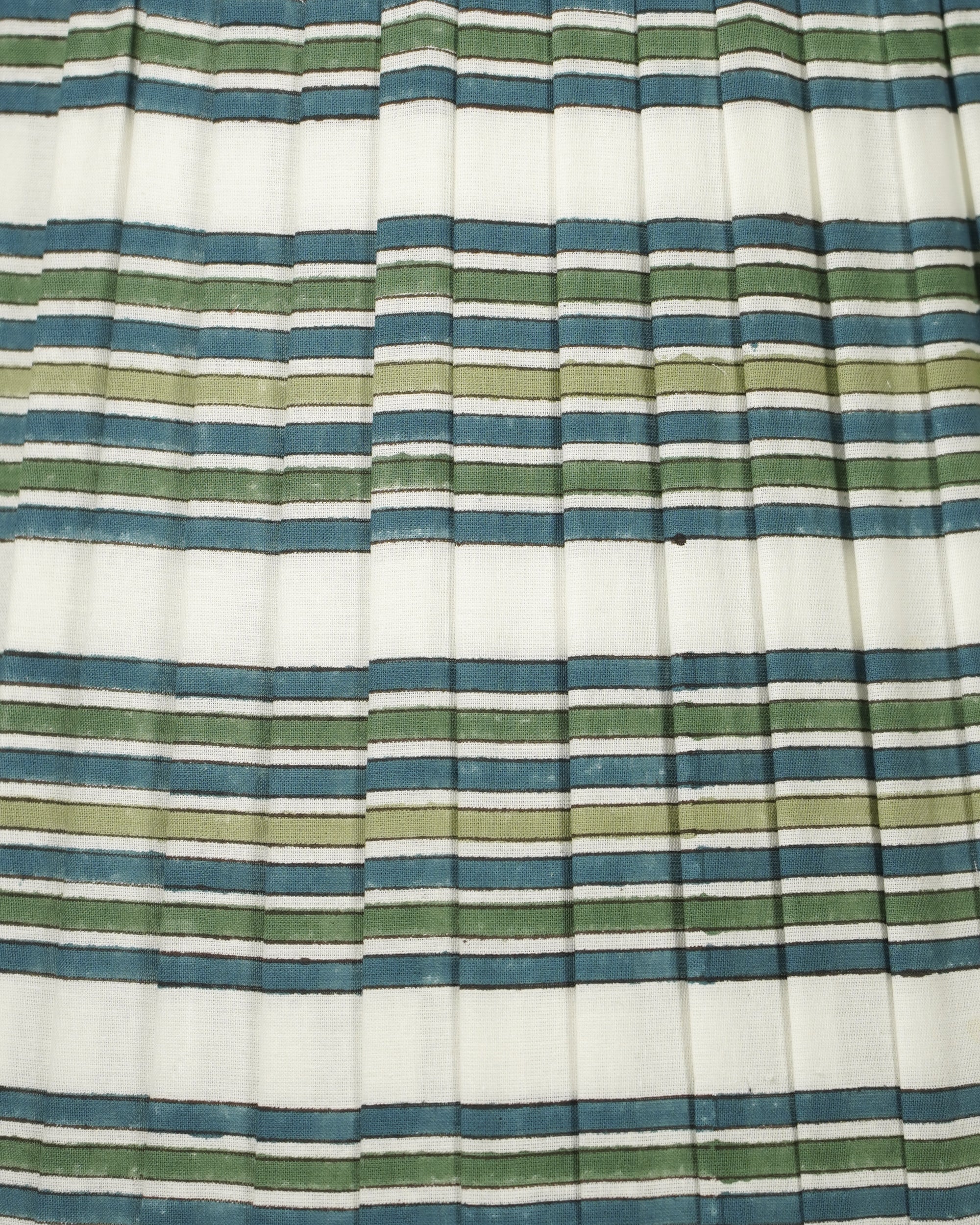 A close-up of a pleated fabric with horizontal stripes in blue, sage green, and olive green on an off-white background.