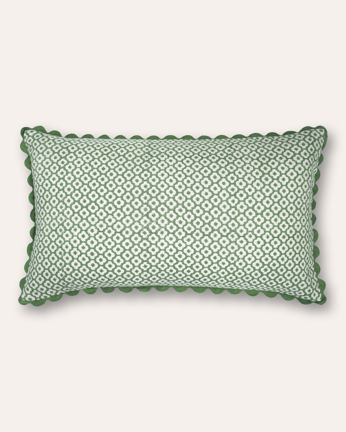 A rectangular cushion featuring a sage green and white geometric diamond pattern, finished with a scalloped green fabric border, shown against a solid off-white background.