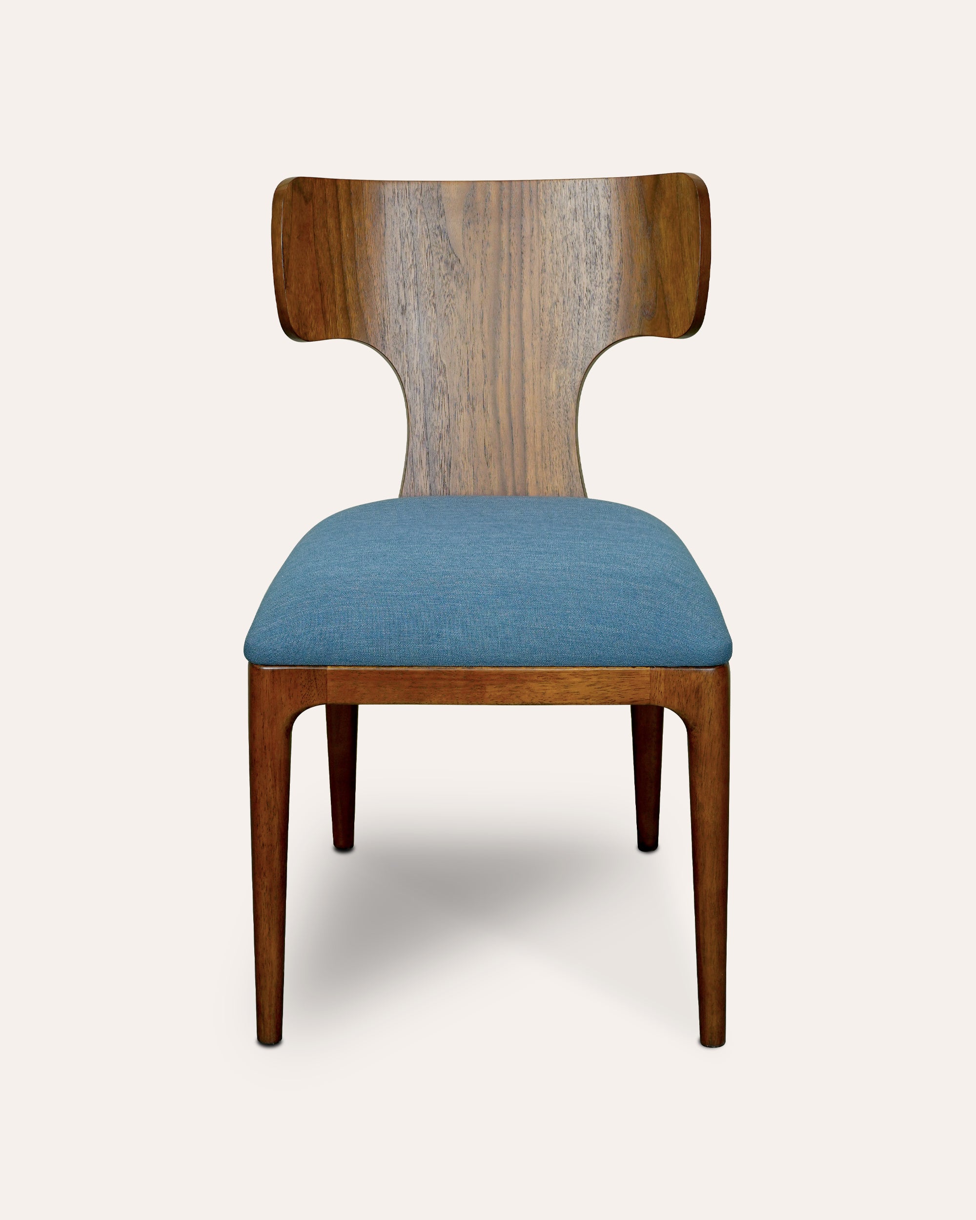 A wooden dining chair with a curved backrest, medium brown wood frame, and blue fabric upholstered seat cushion, shown against a solid off-white background.