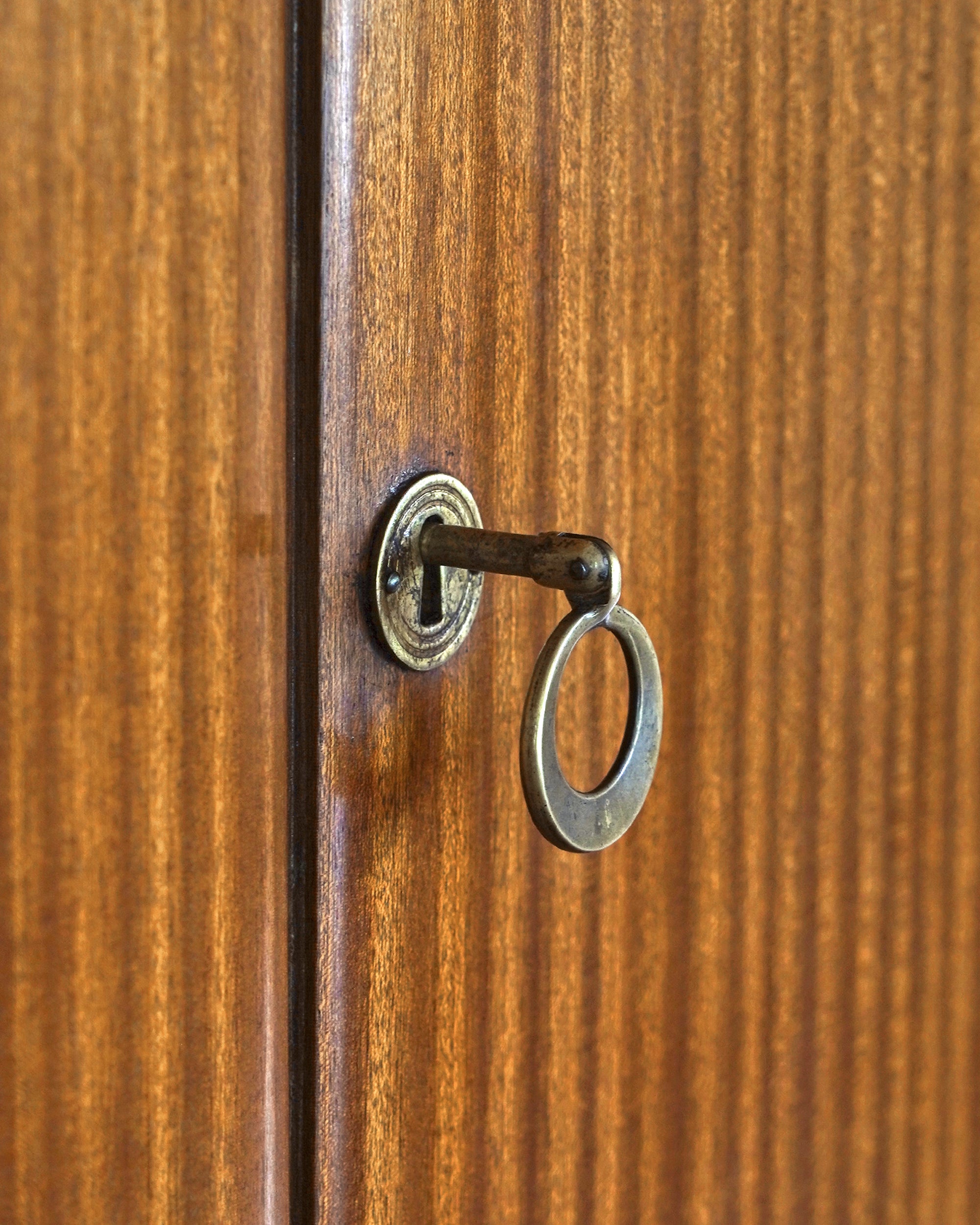 Close-up of a wooden door with a keyhole and key.