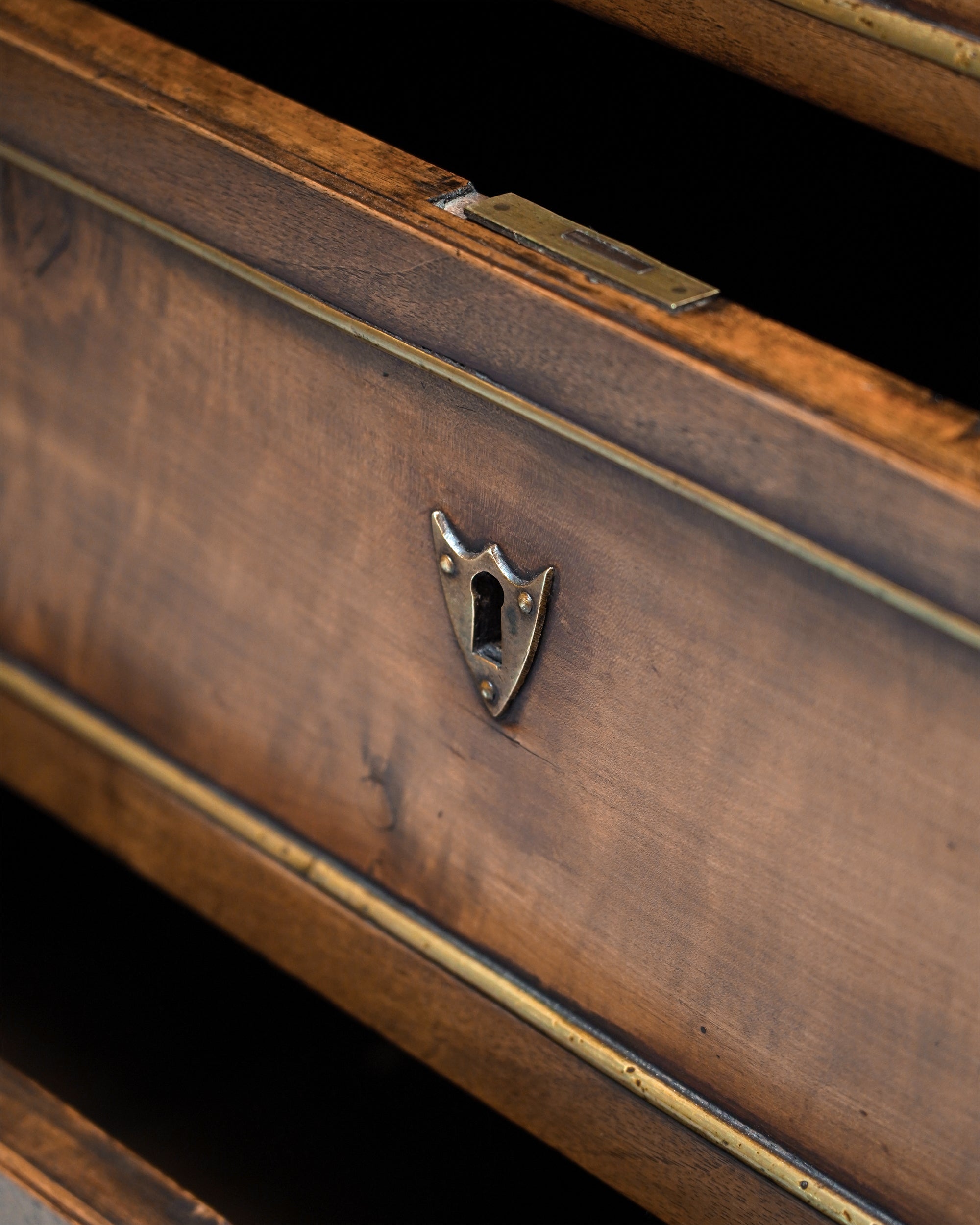 Close-up of a wooden box with a metallic clasp on a black background