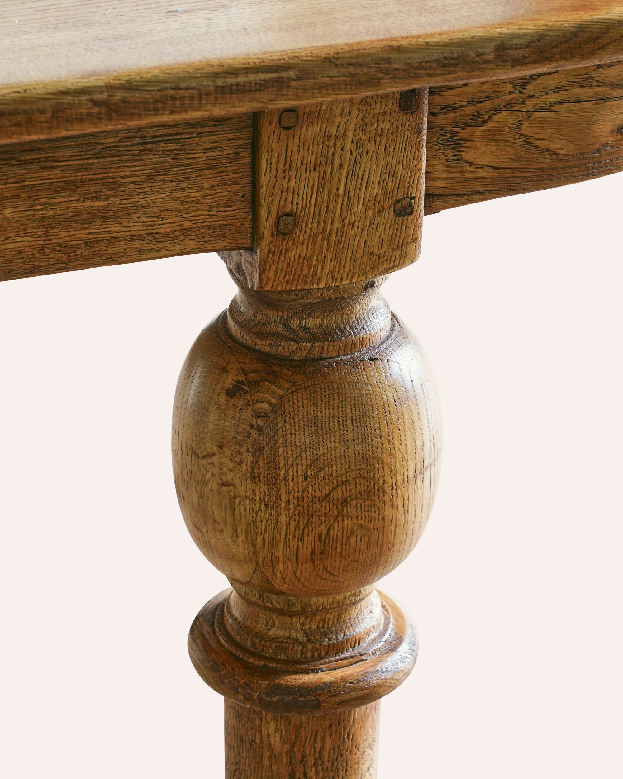 Close-up of a wooden table leg with a white background