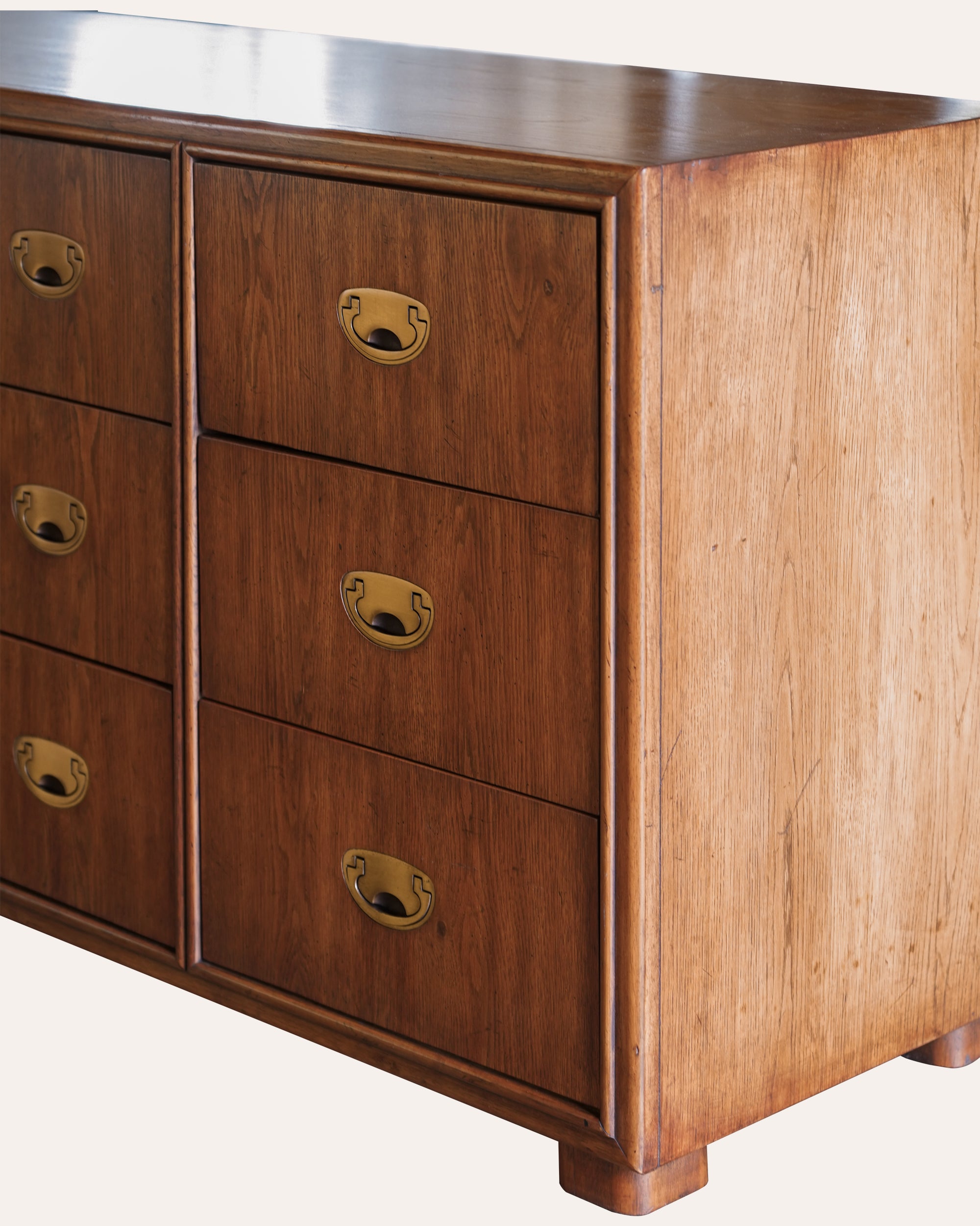 Wooden dresser with brass handles on a white background