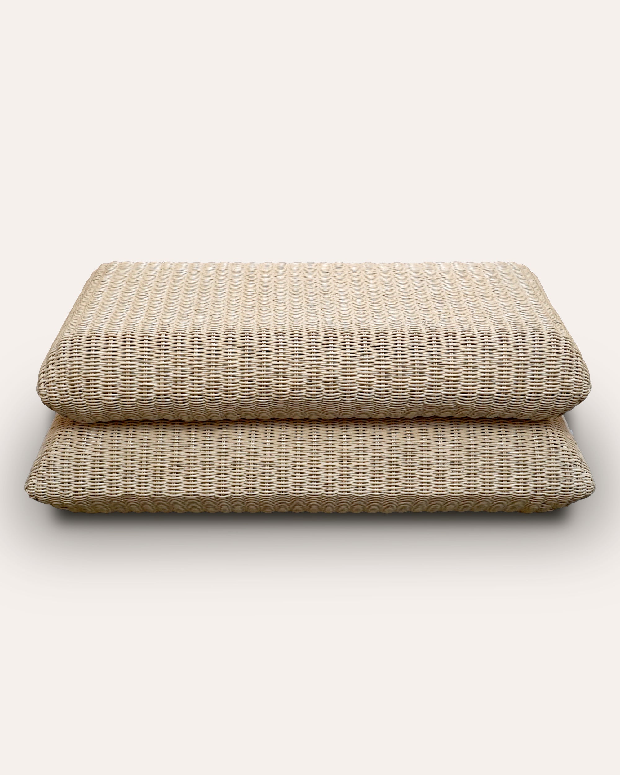 Natural rattan ottoman with inclosed storage space on a white background