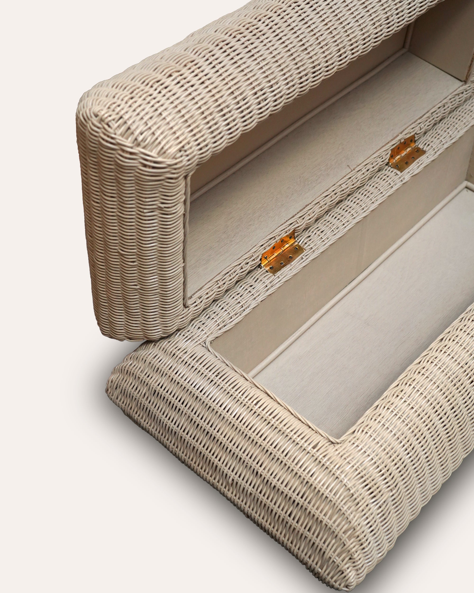 Close-up of a wicker ottoman with a lid open on a light background