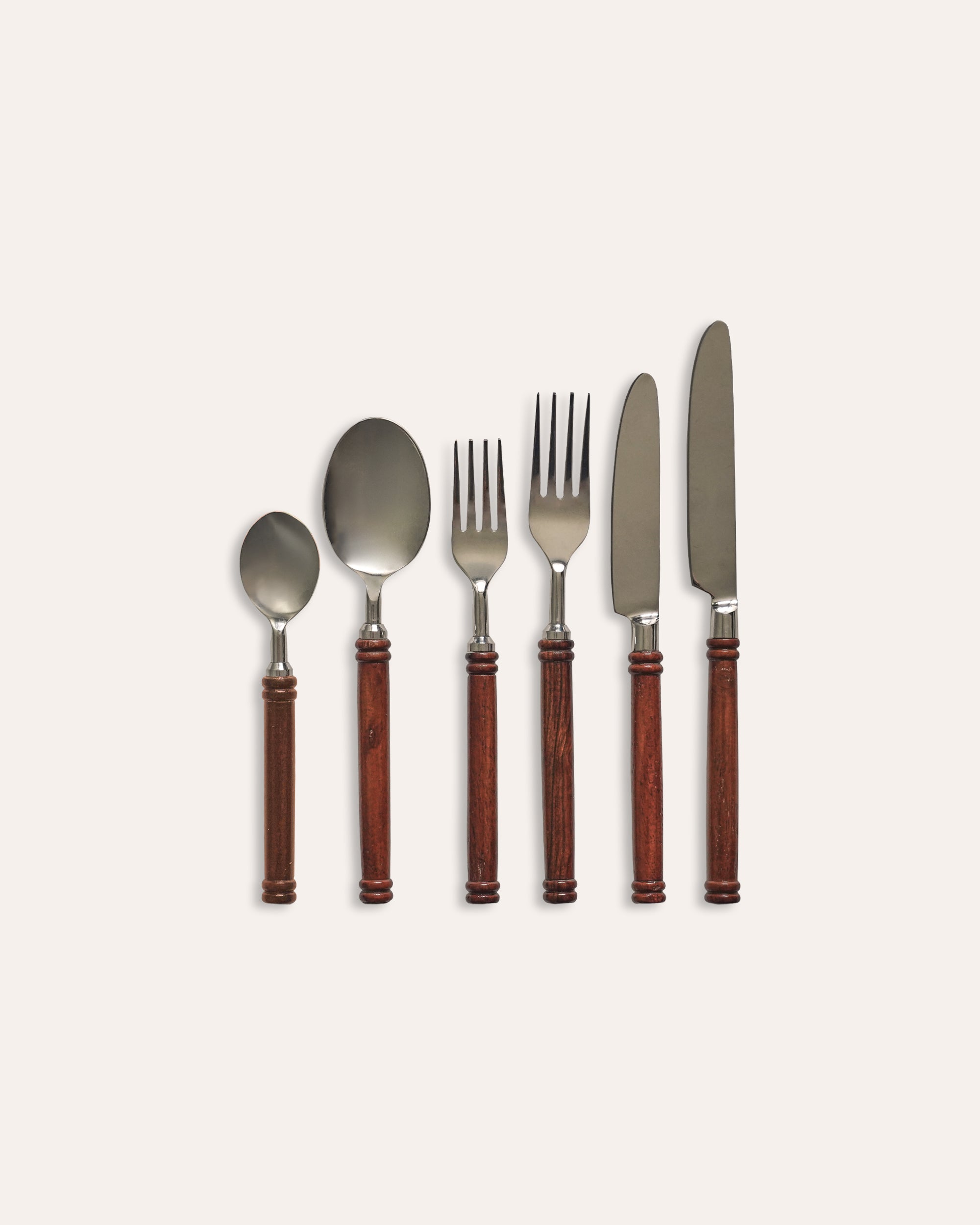 Set of silverware with wooden handles on a light beige background