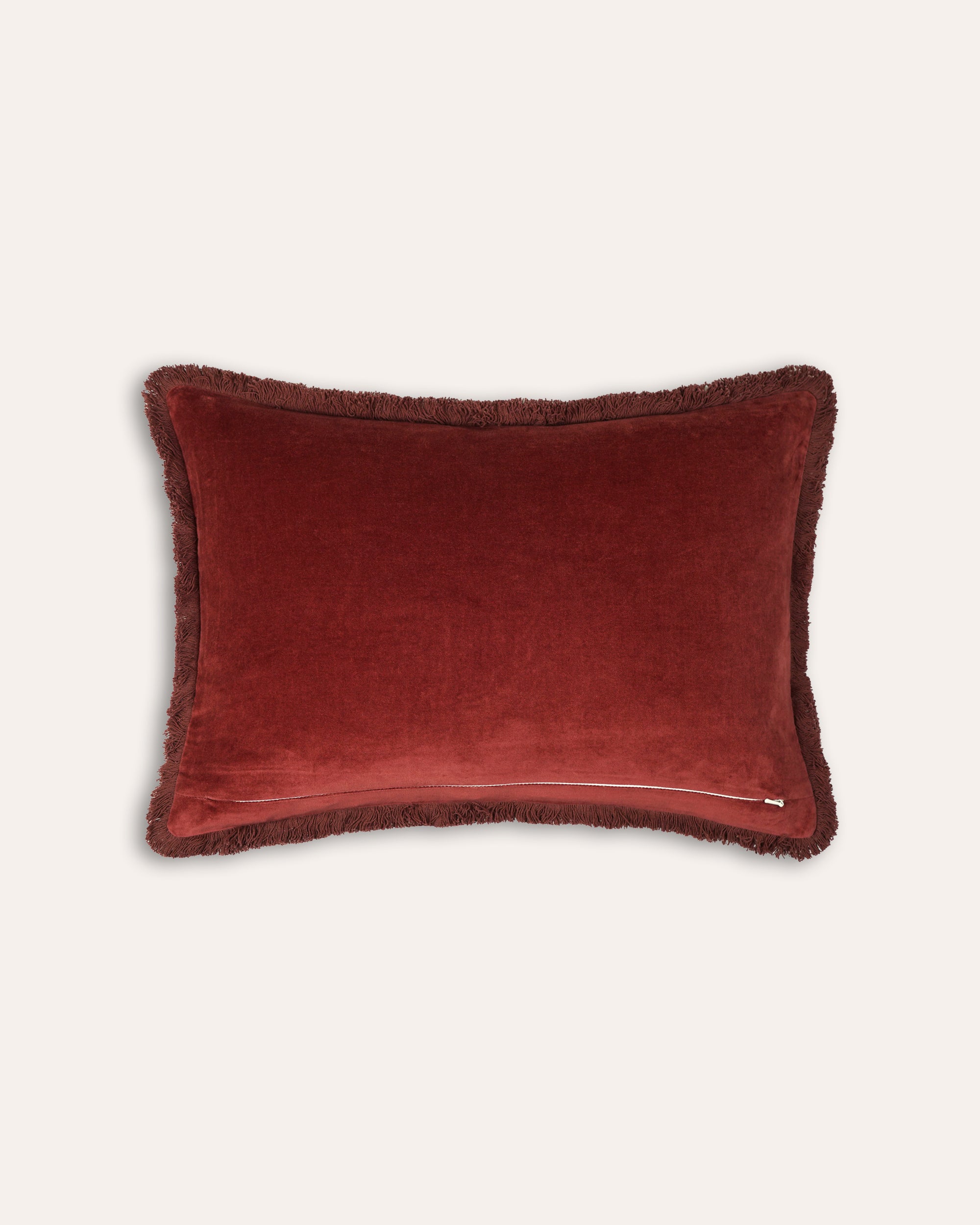 Red velvet pillow on a light beige background