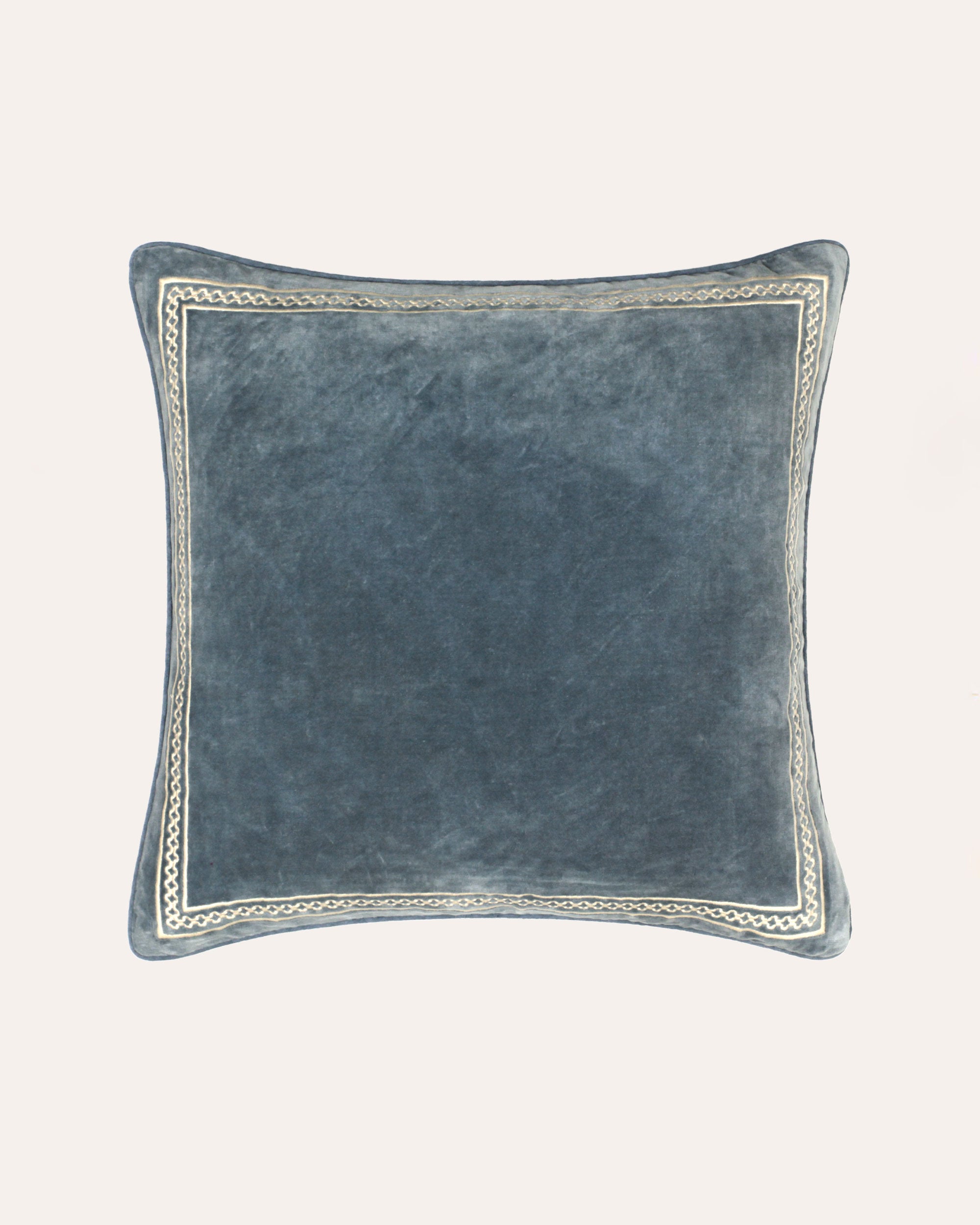 A square-shaped indigo blue velvet cushion with an embroidered border.