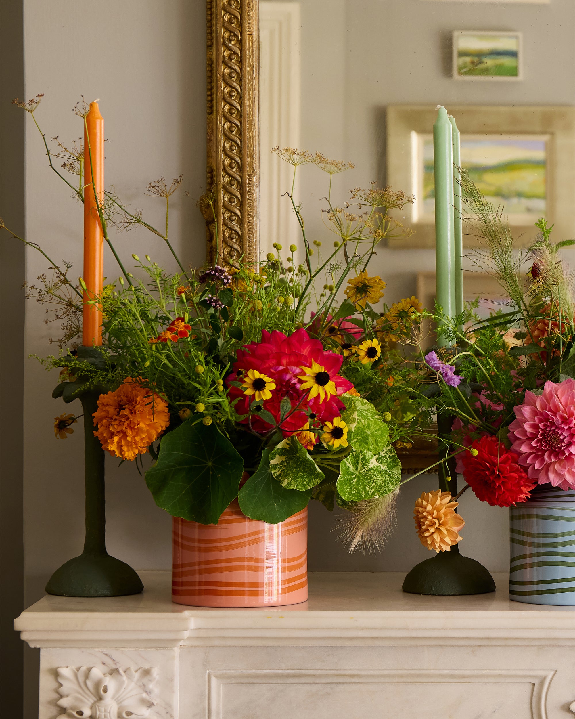 Fireplace styled with the orange and pink maypole vase and palm tree candlesticks