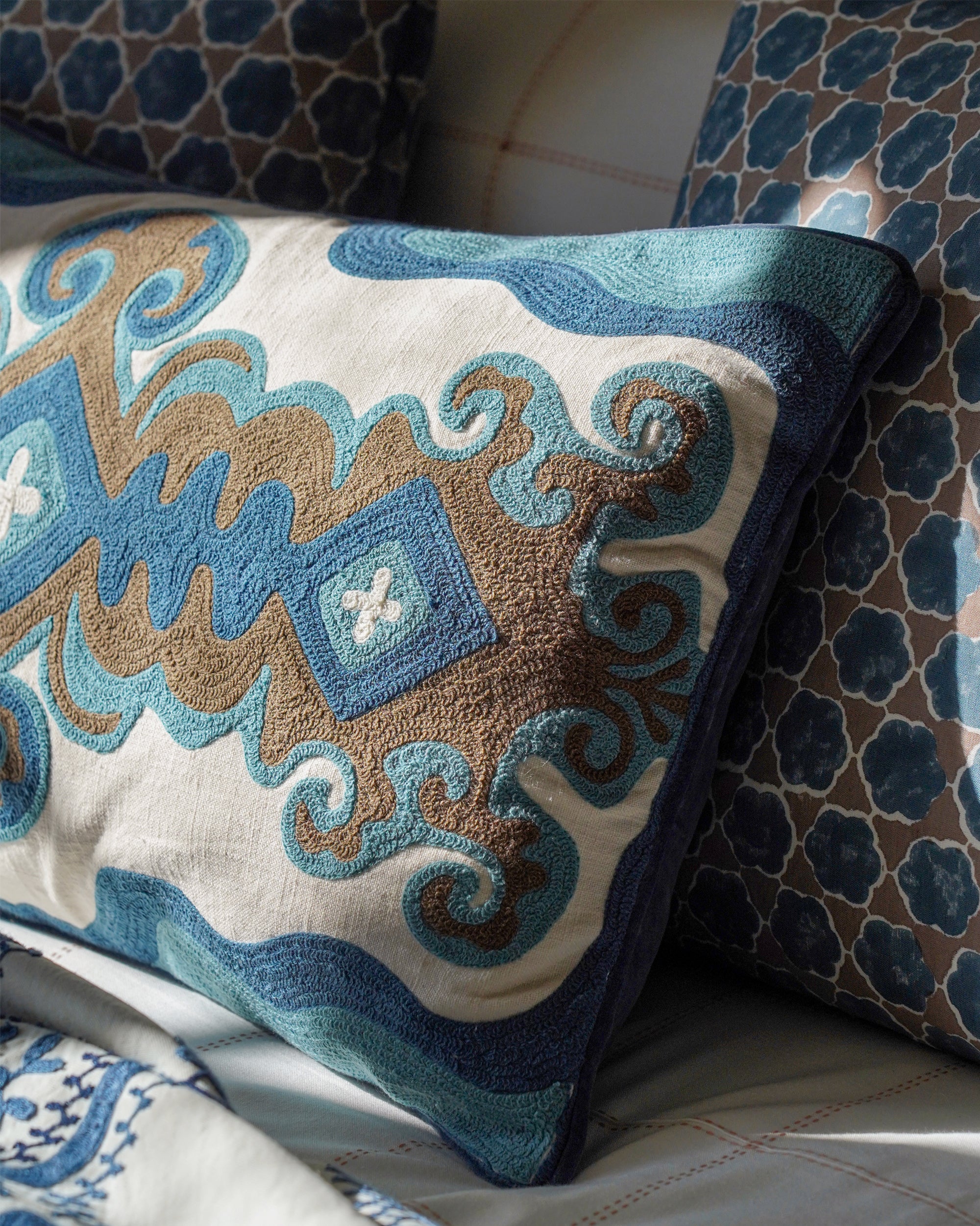 Decorative cushion with intricate patterns on a bed