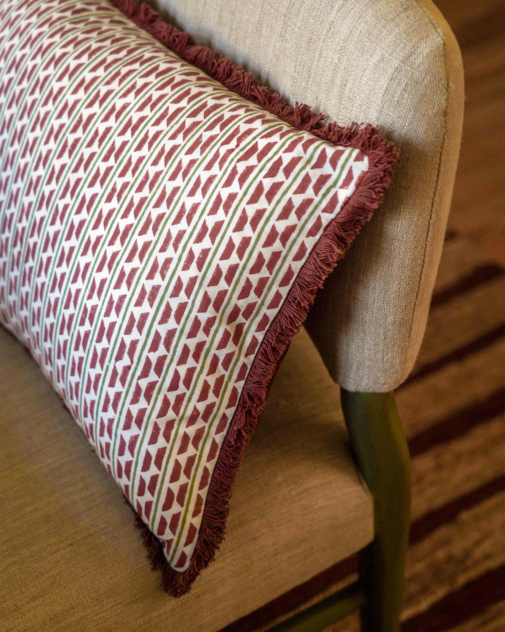 Patterned cushion on a beige chair with wooden legs