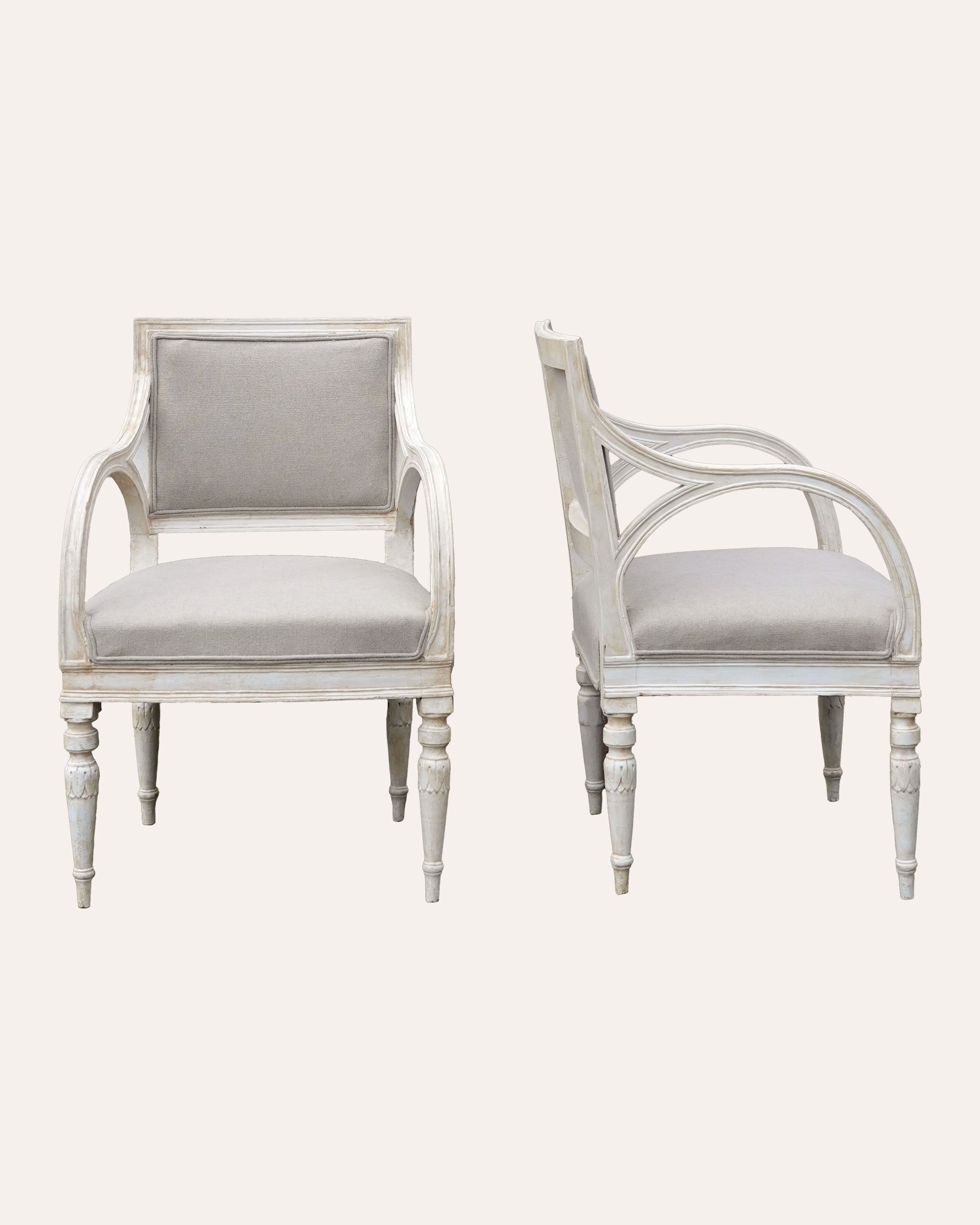 Pair of white armchairs with grey cushions on a white background