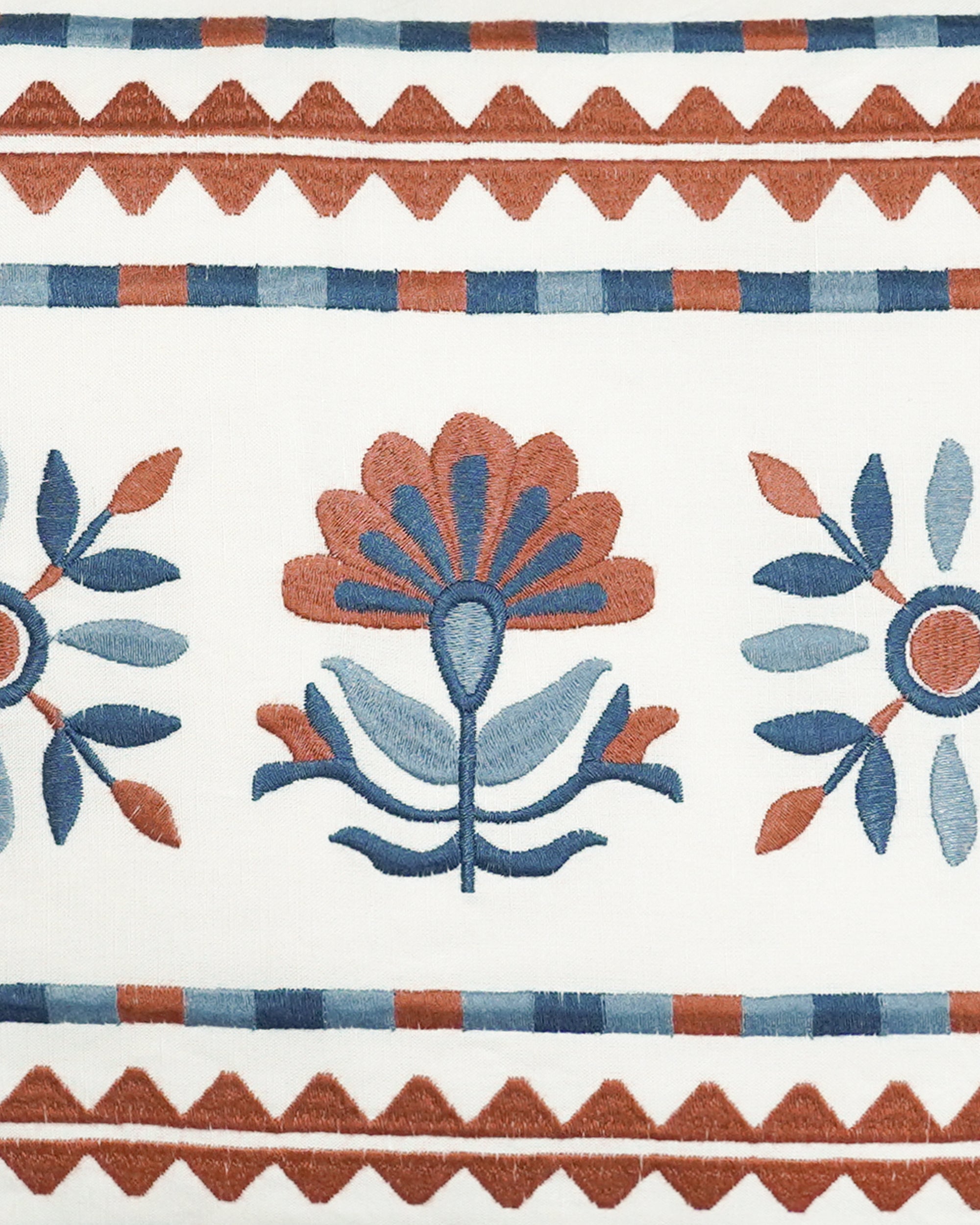 Close up detail image of the blue and red Sancti embroidered rectangular cushion