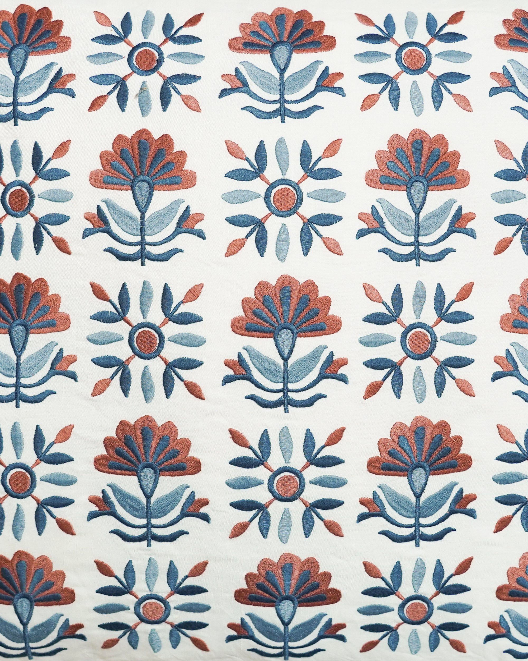 Close up detail image of the blue and red Sancti embroidered square cushion