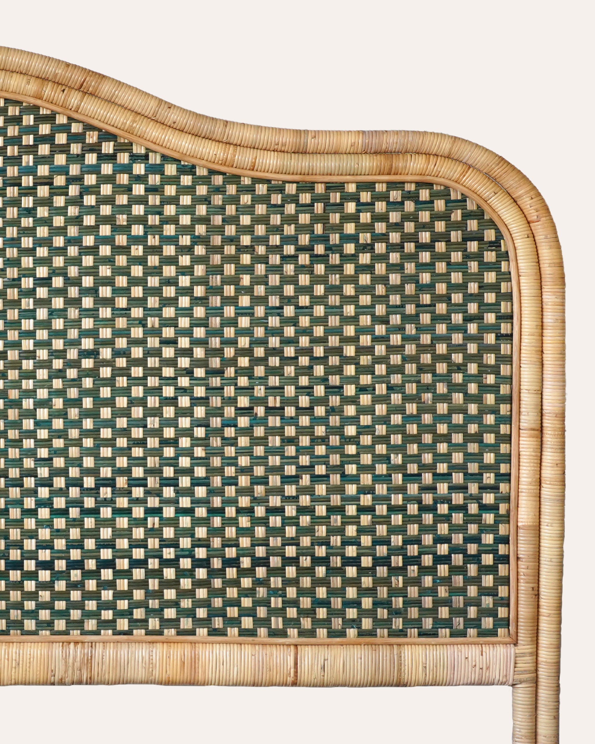 Woven rattan headboard with green and beige pattern on a white background