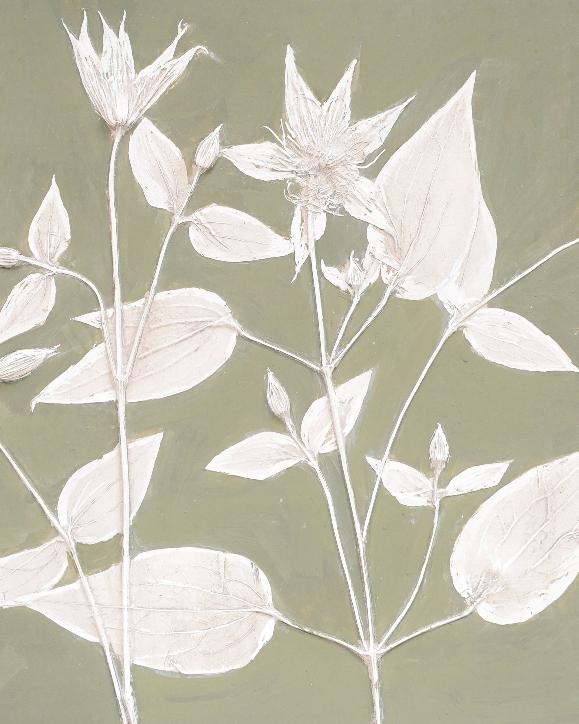 White floral wall art on a green background