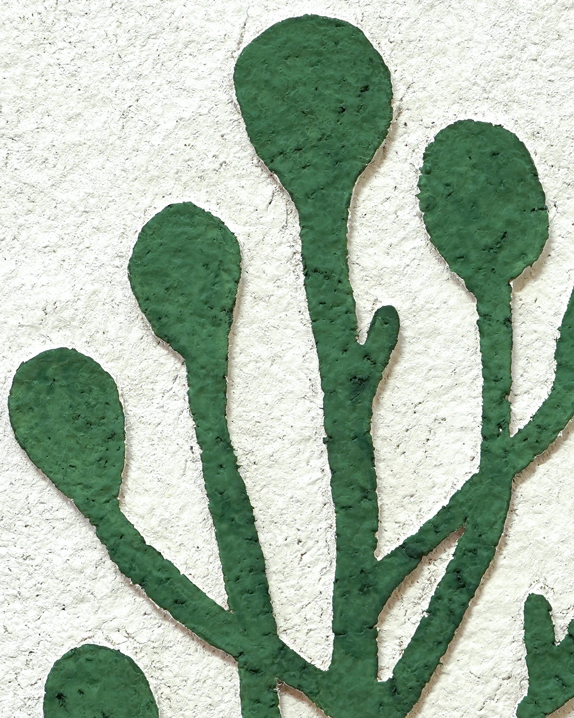 Close-up of green leaf-like shapes on a textured beige background