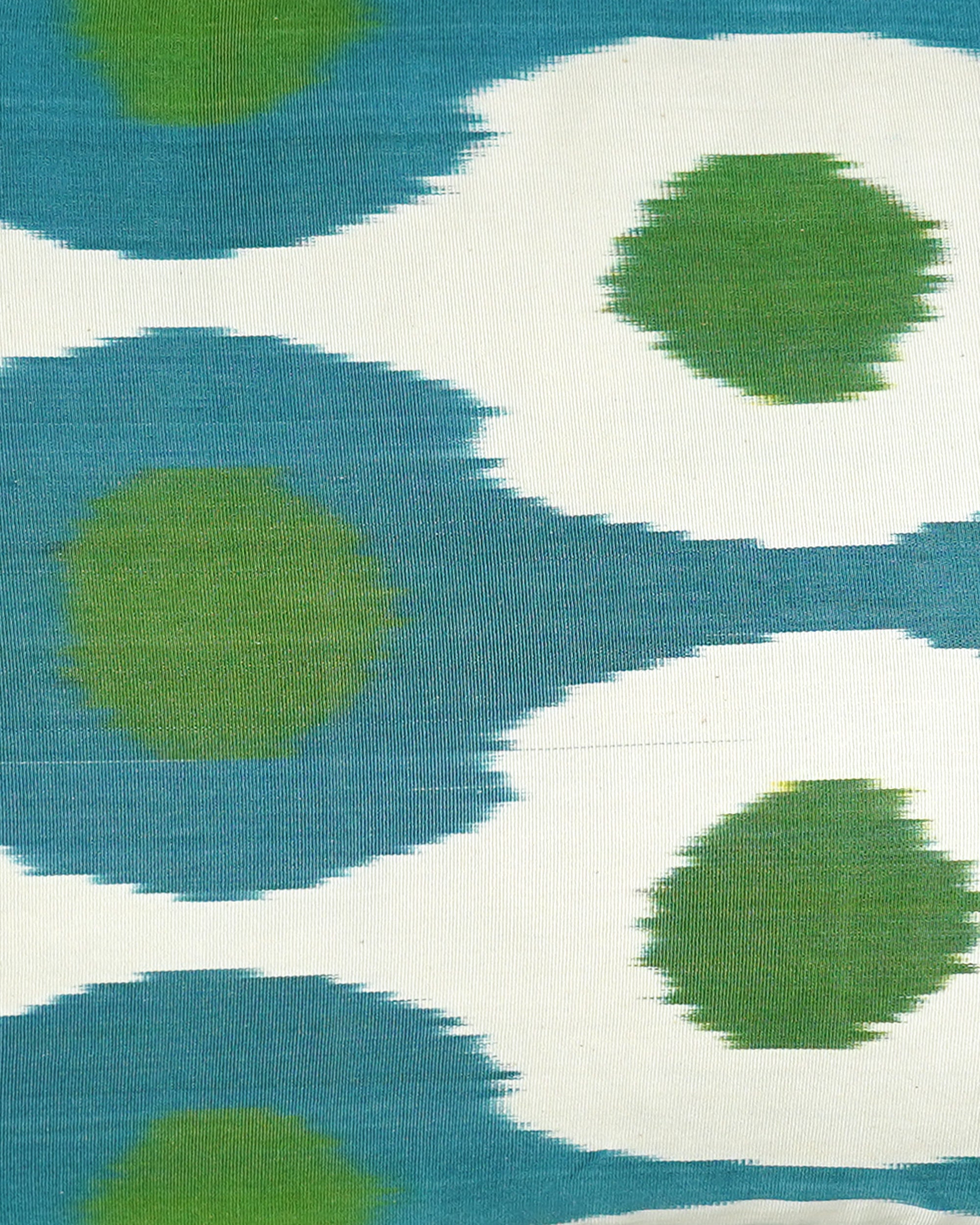 Patterned Ikat fabric with green and blue shapes on a white background