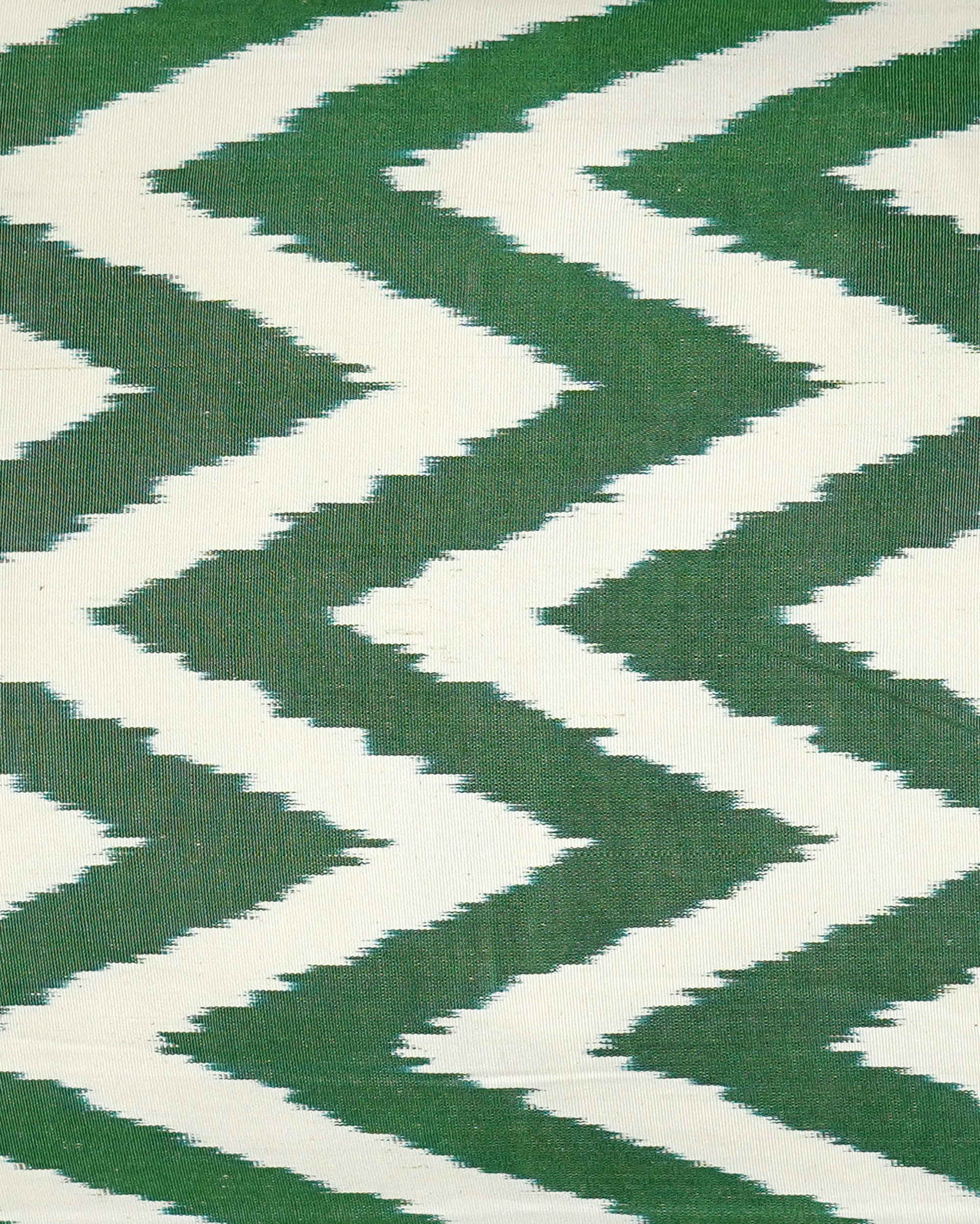 Close up Ikat detail of green and white chevrons on a textured fabric background