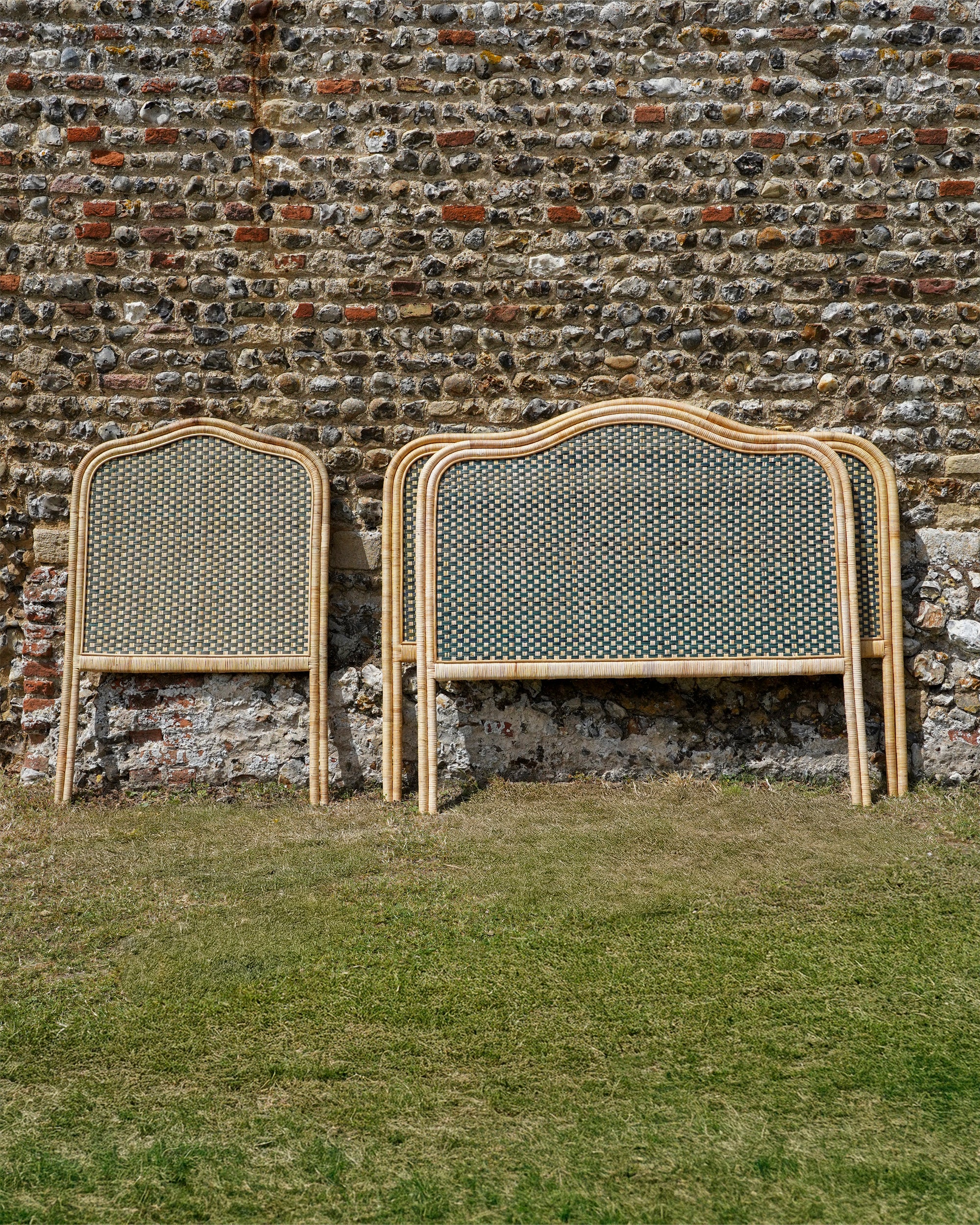 Rattan headboards against a stone wall.