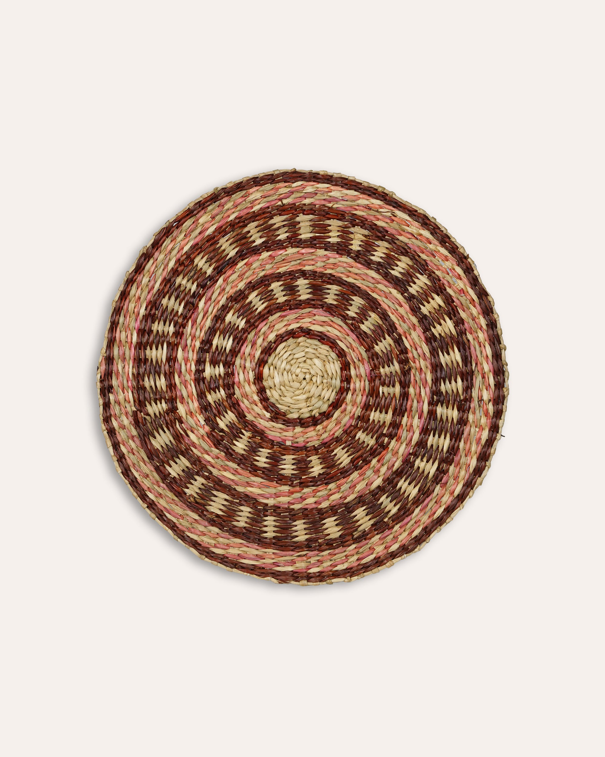 Round woven placemat with concentric circle pattern on a beige background