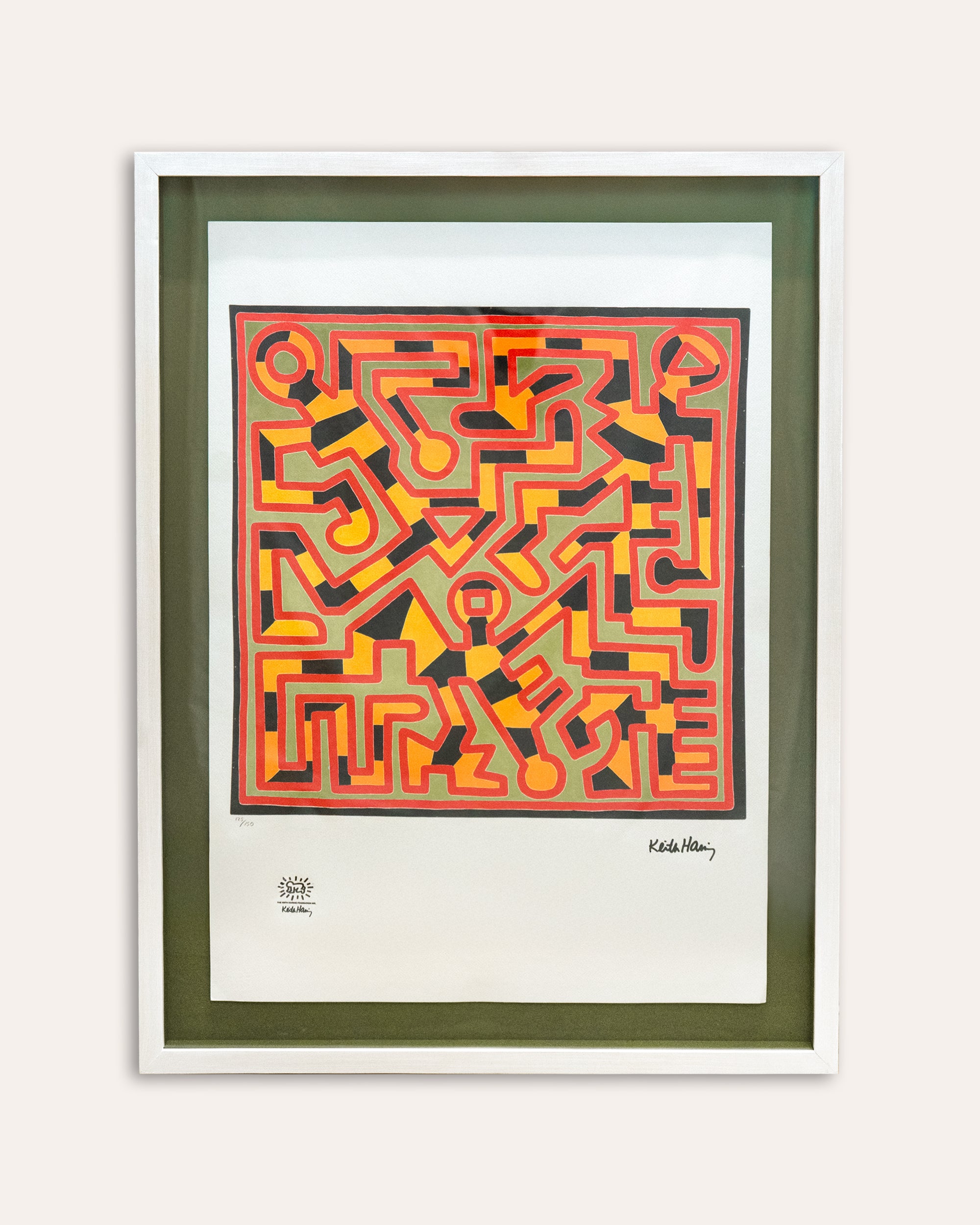 Framed abstract artwork with geometric patterns in red, orange, and green on a white background.