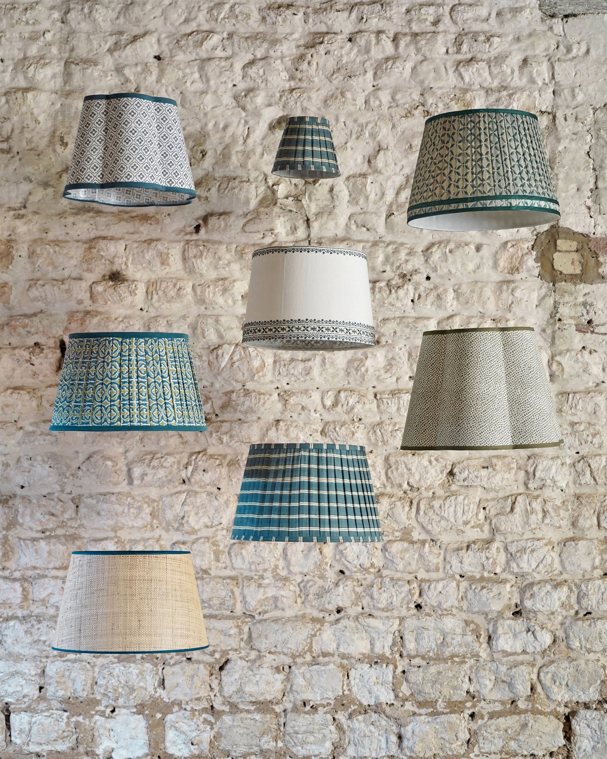 A range of Birdie Fortescue's blue lampshades hanging from the ceiling