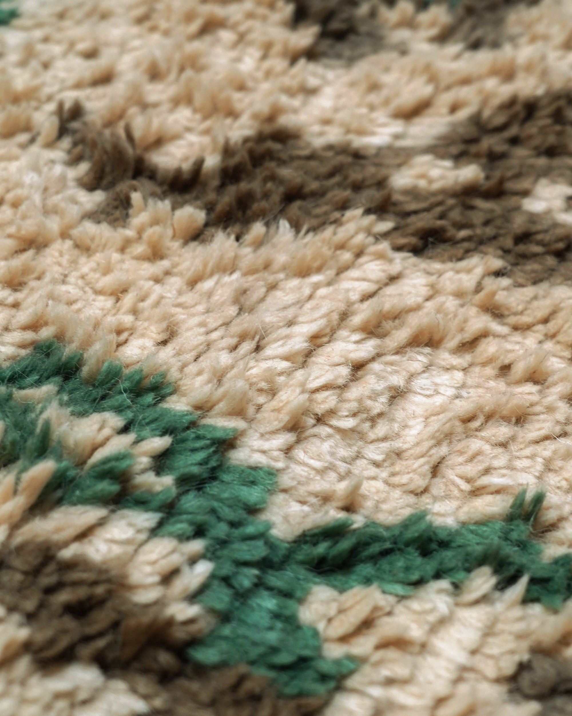 Close-up of a textured fabric with green and beige patterns