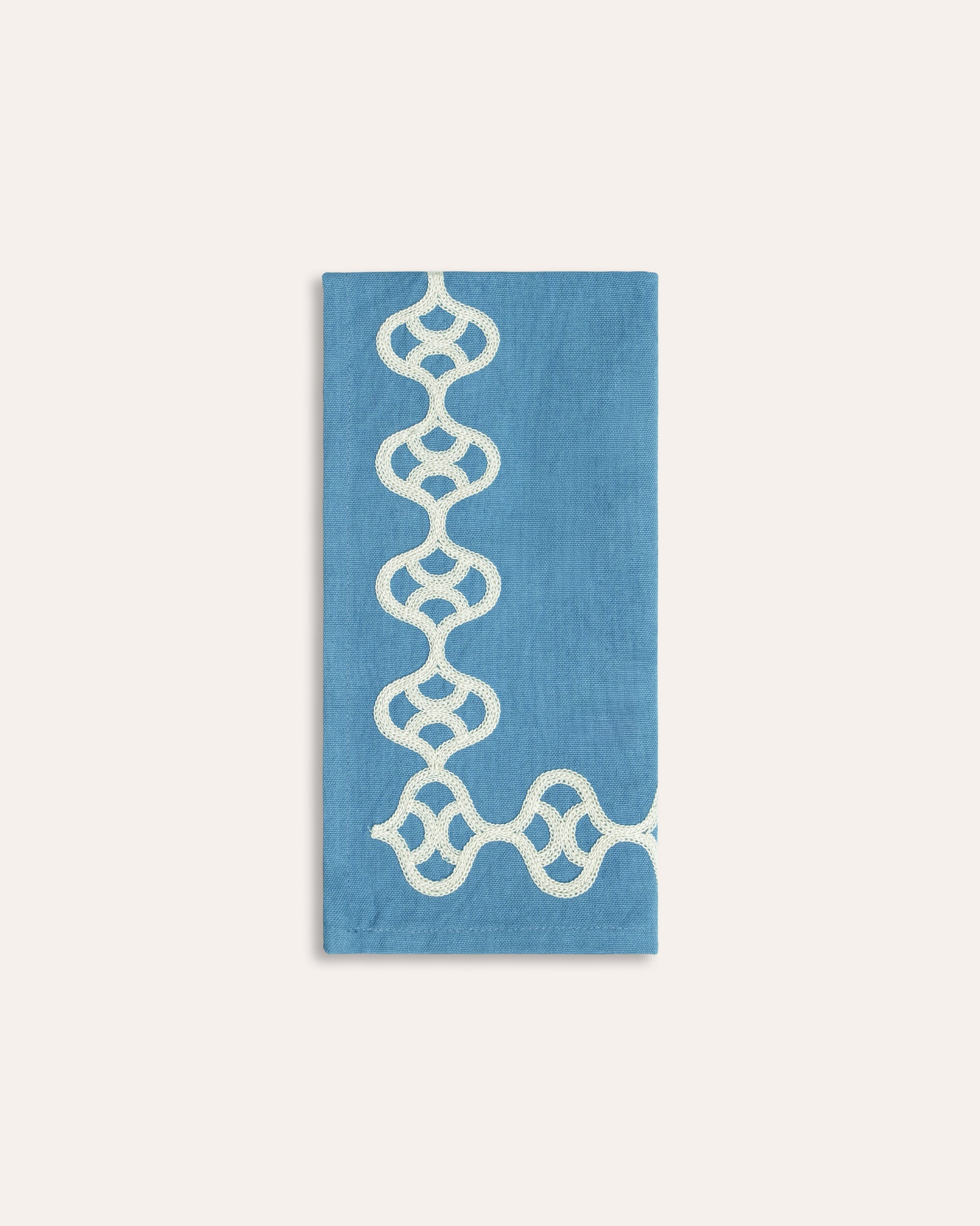 Blue individual napkin white geometric pattern on a light grey background