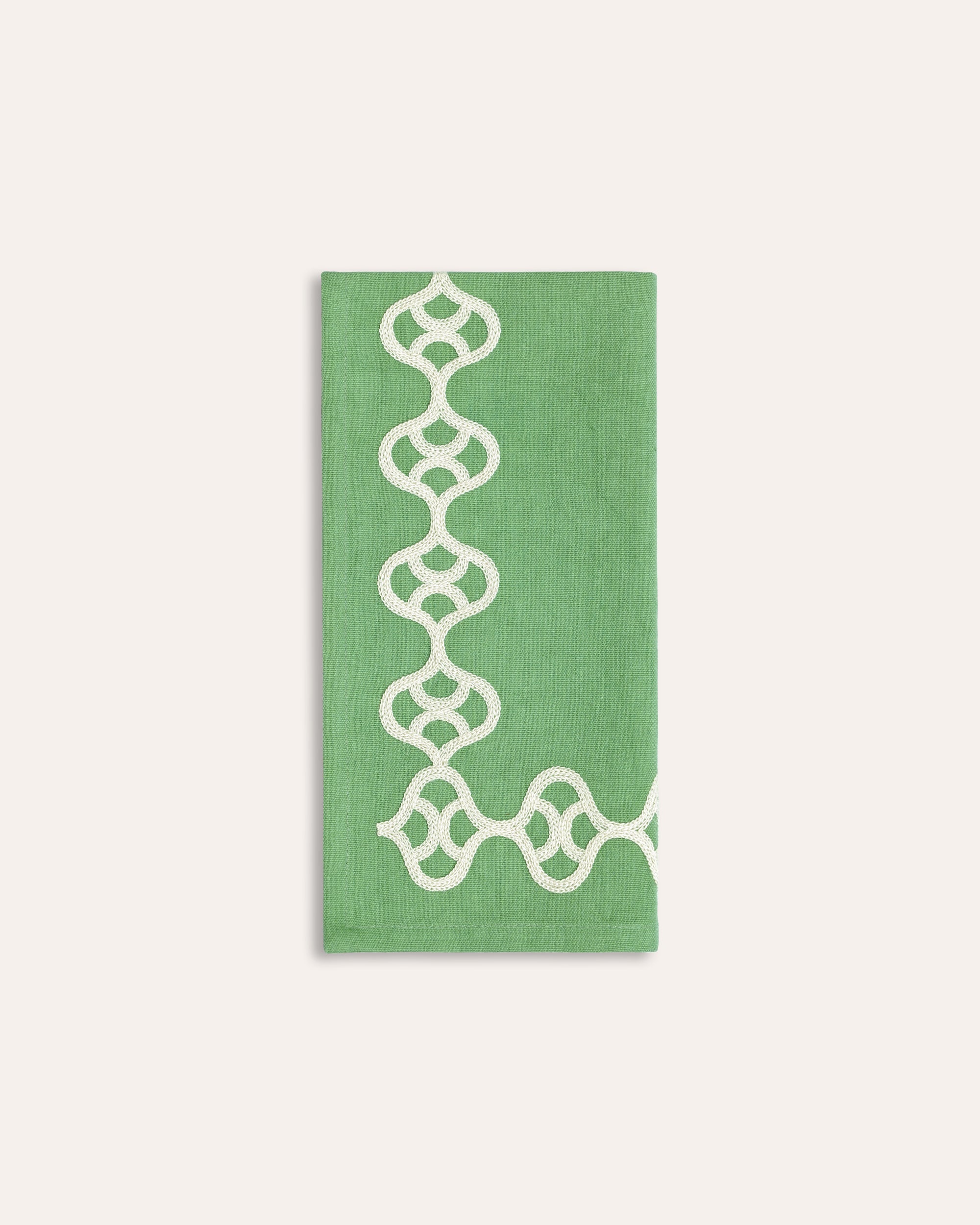 Green napkin with white geometric pattern on a white background