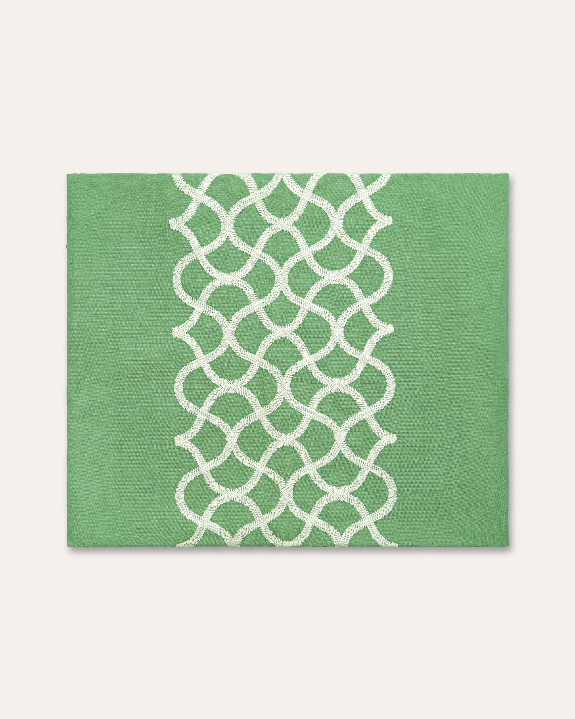 Green tablecloth with a white geometric pattern on a white background