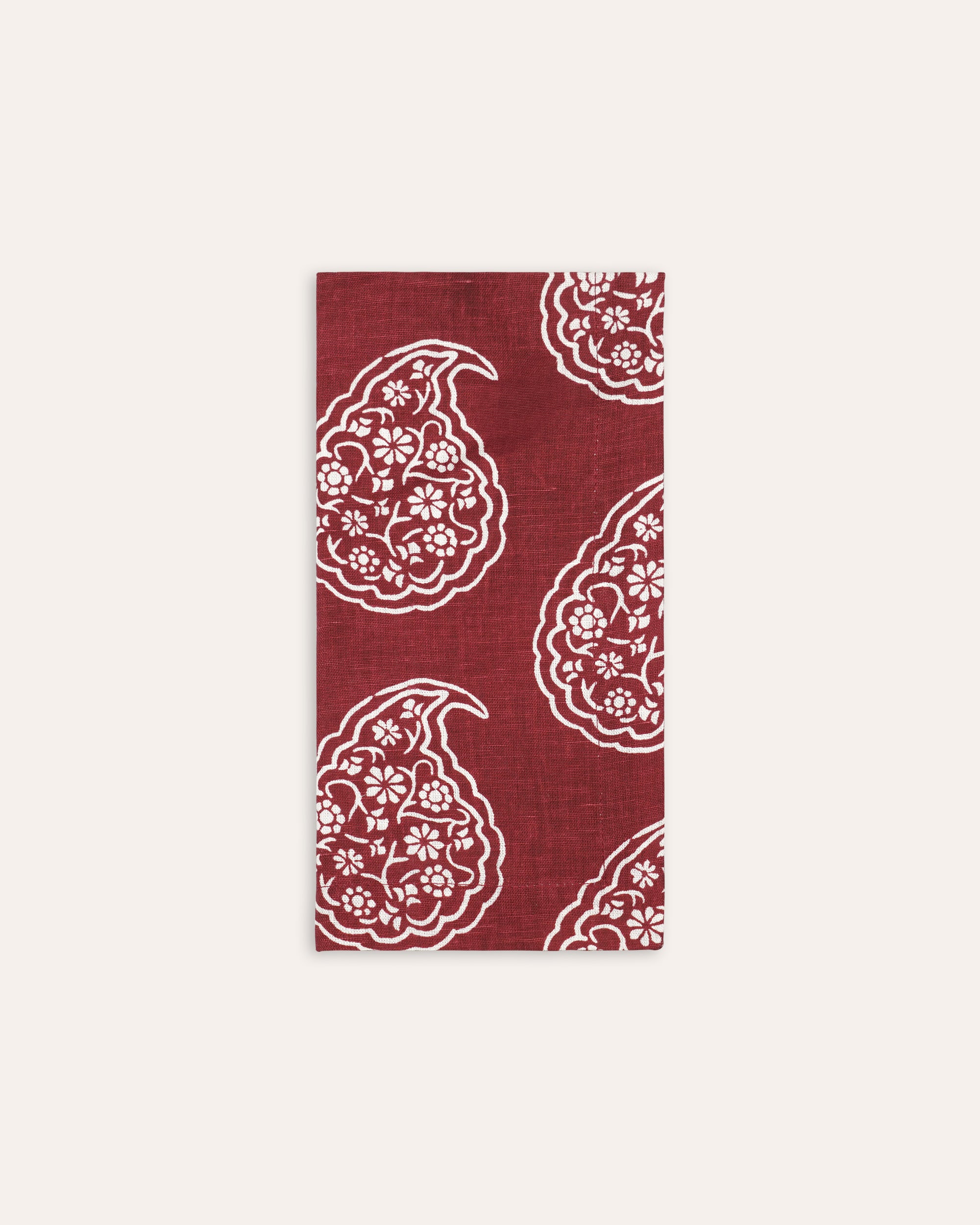 Red and white floral paisley individual napkin on a taupe background