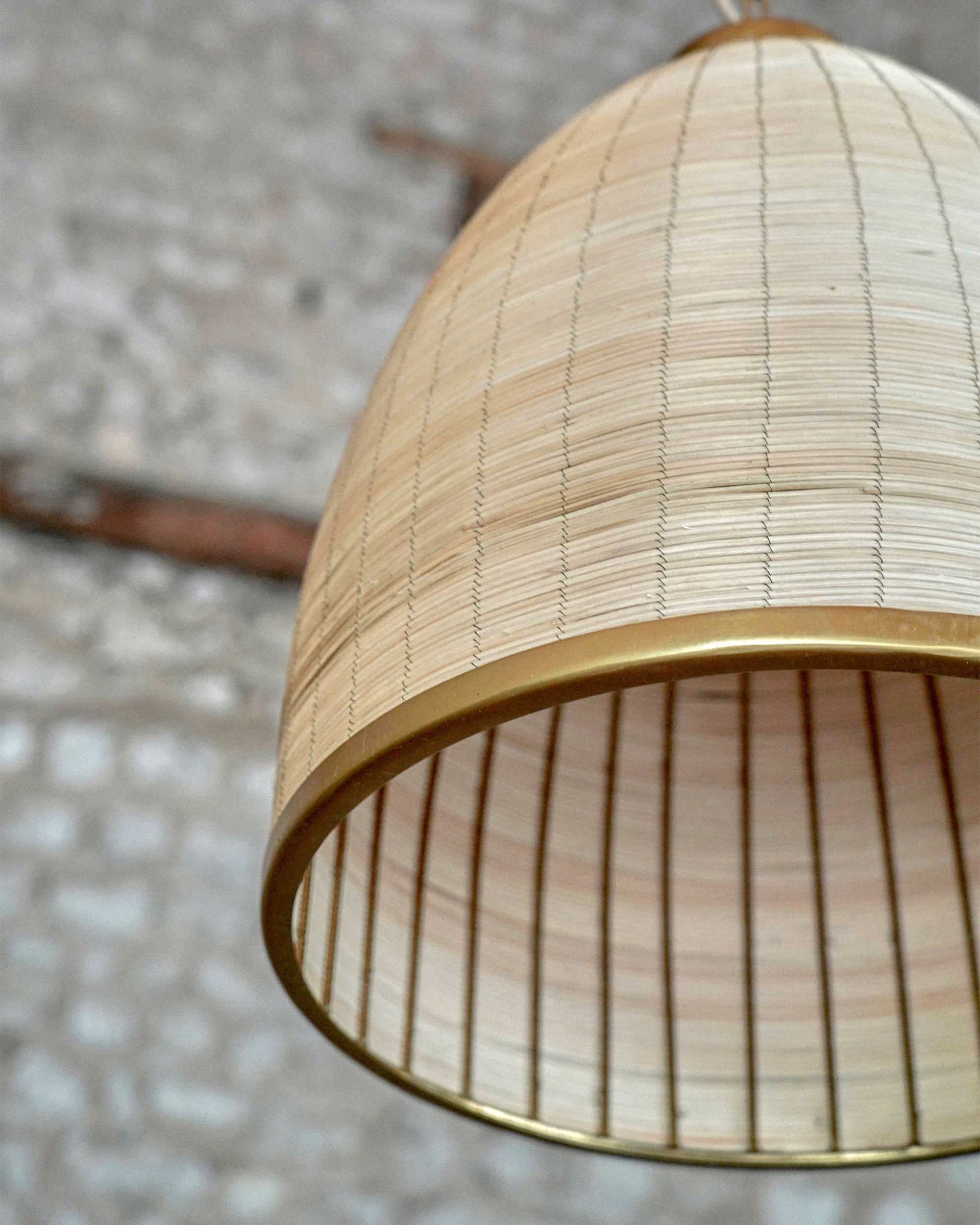 Close-up of a woven lampshade with a textured background