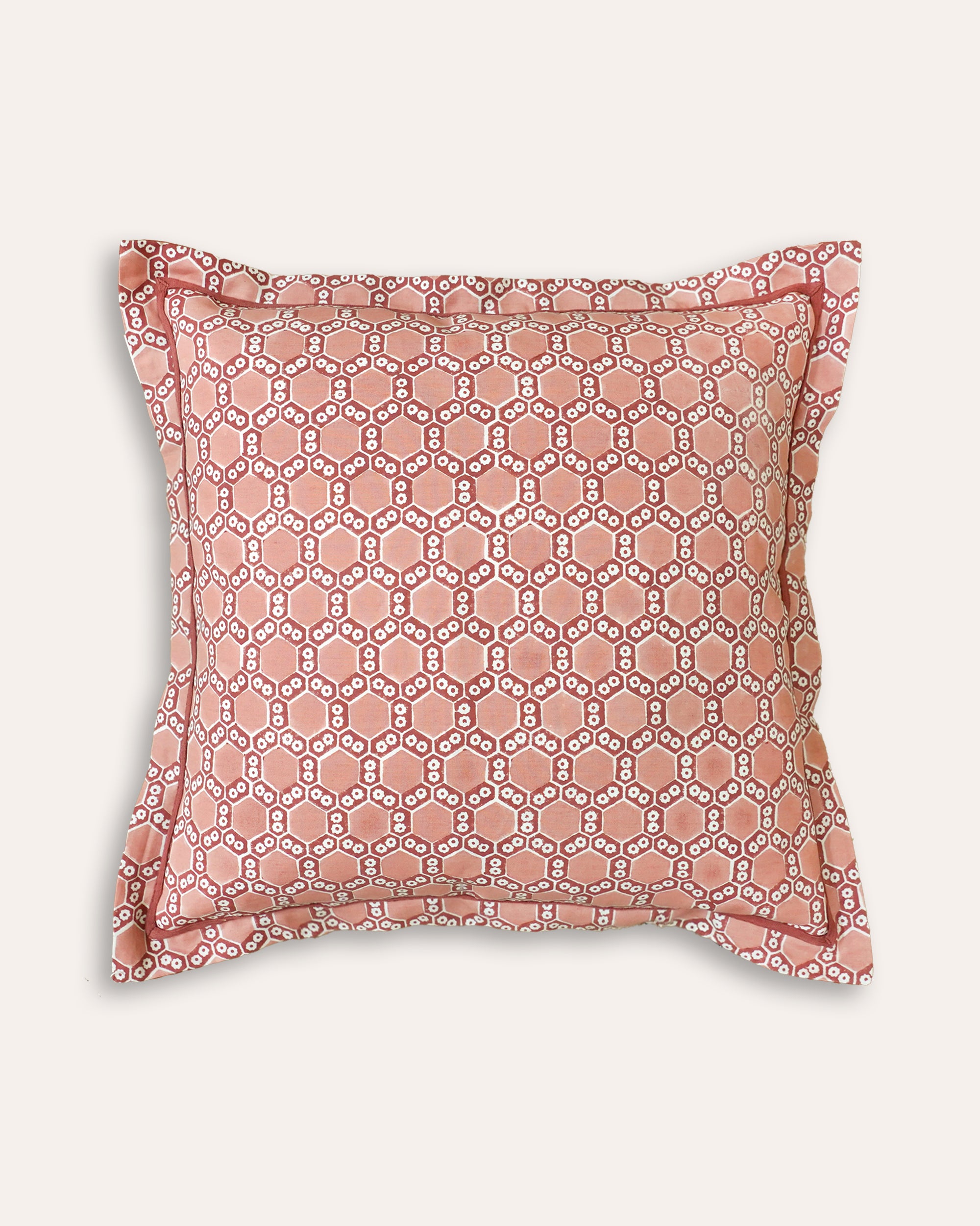 Decorative square cushion with pink and red geometric pattern on a white background