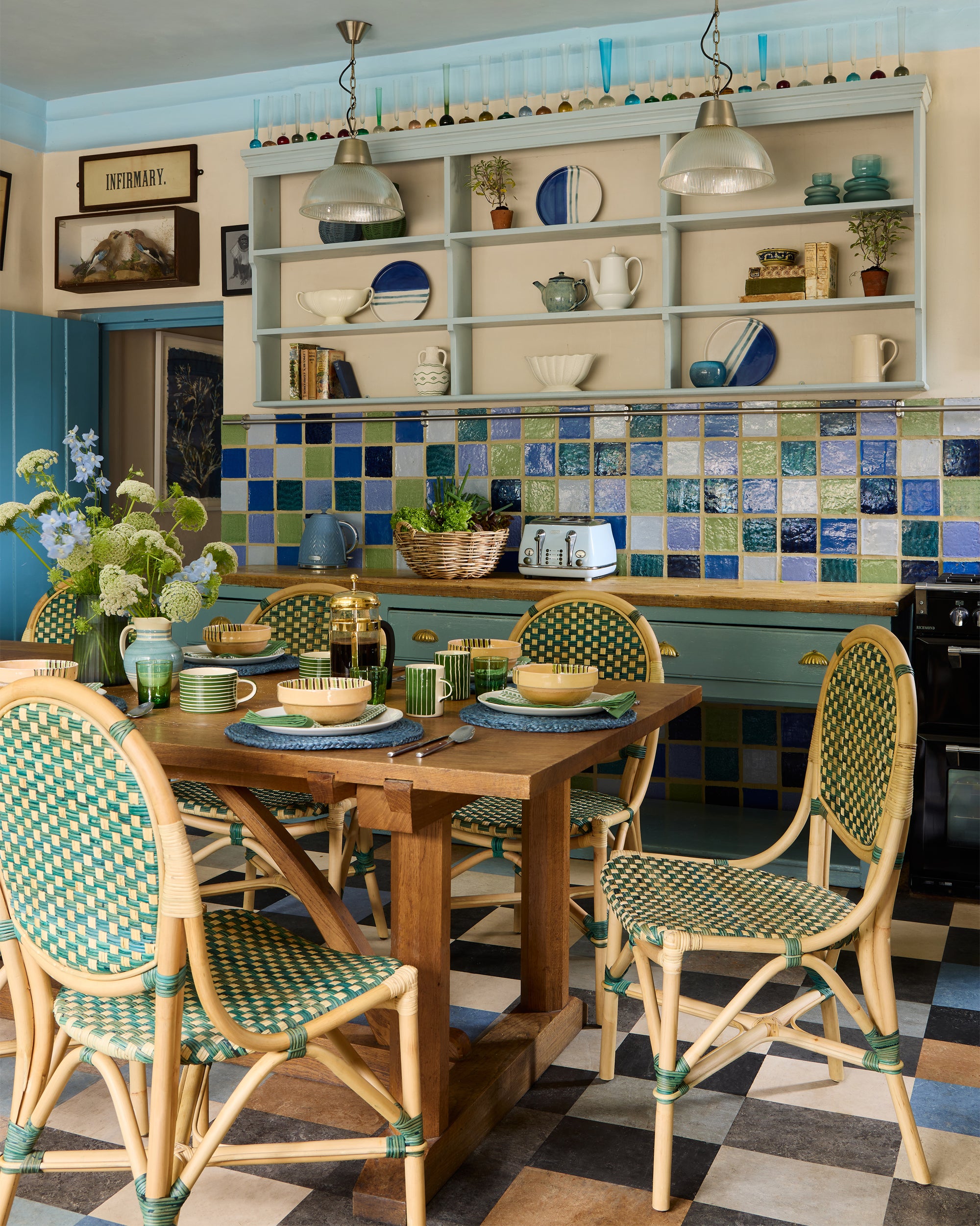 Dining area with wooden table and rattan dining chairs, colorful tile backsplash, and decorative elements.
