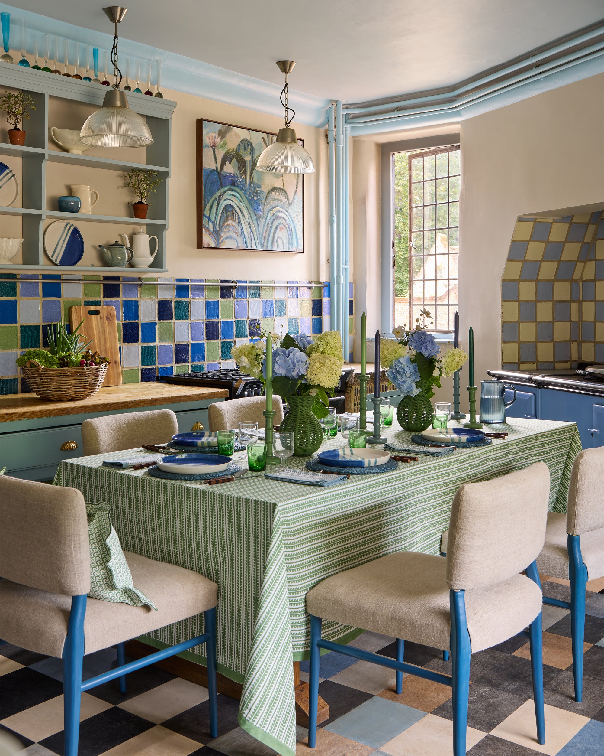 Dining room with a table set for a meal, chairs, and a checkered floor.