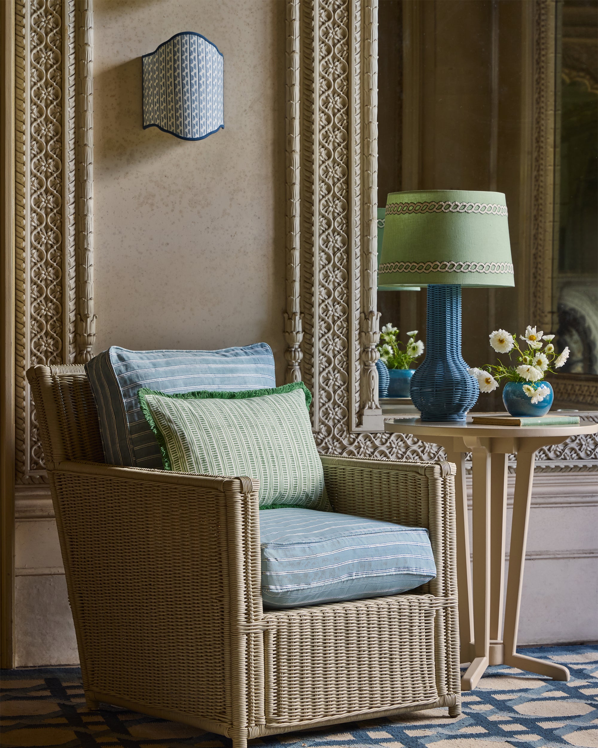 Wicker armchair with cushions in a stylish room with decorative elements.