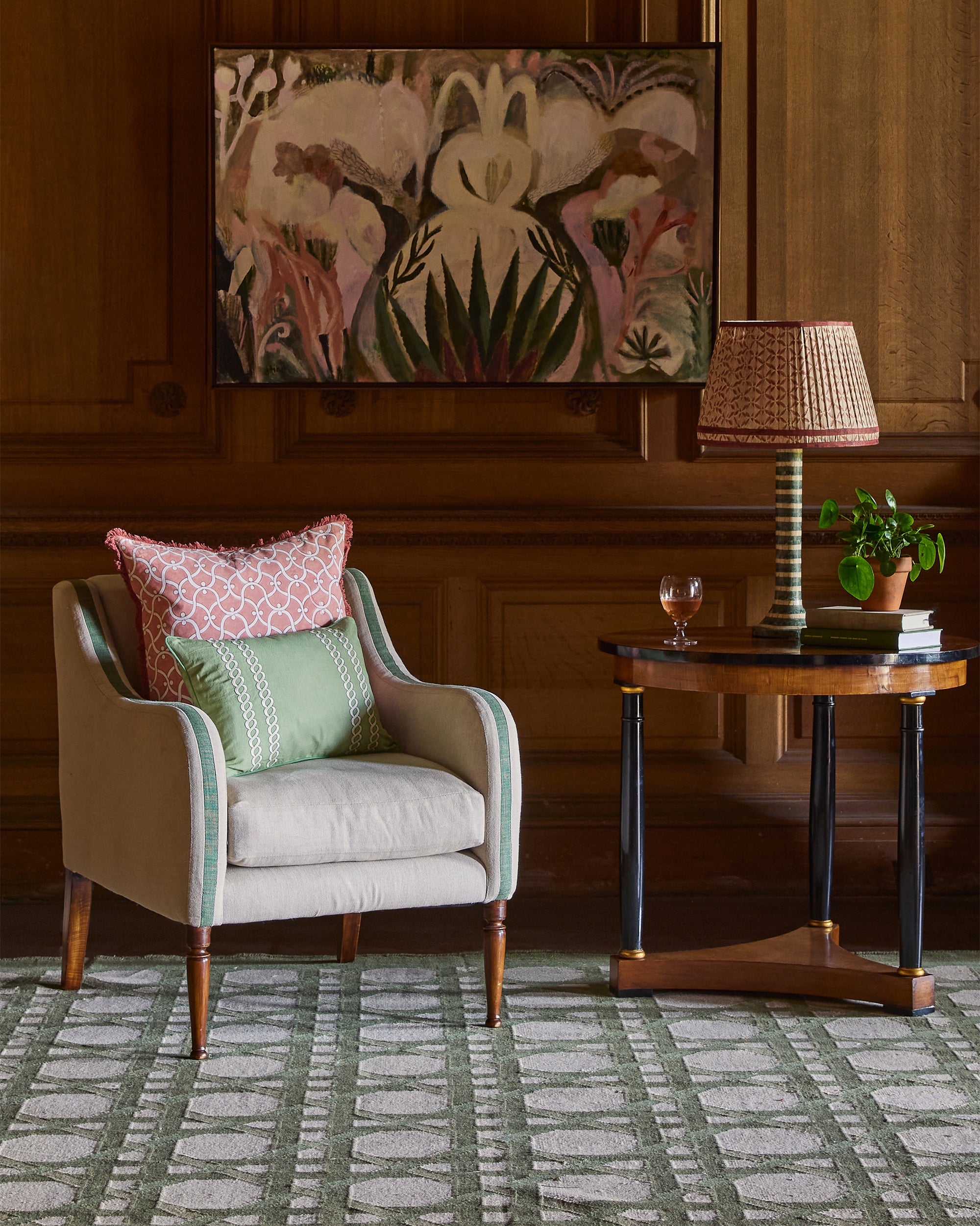 Living room with a beige armchair, side table, and decorative painting on the wall.